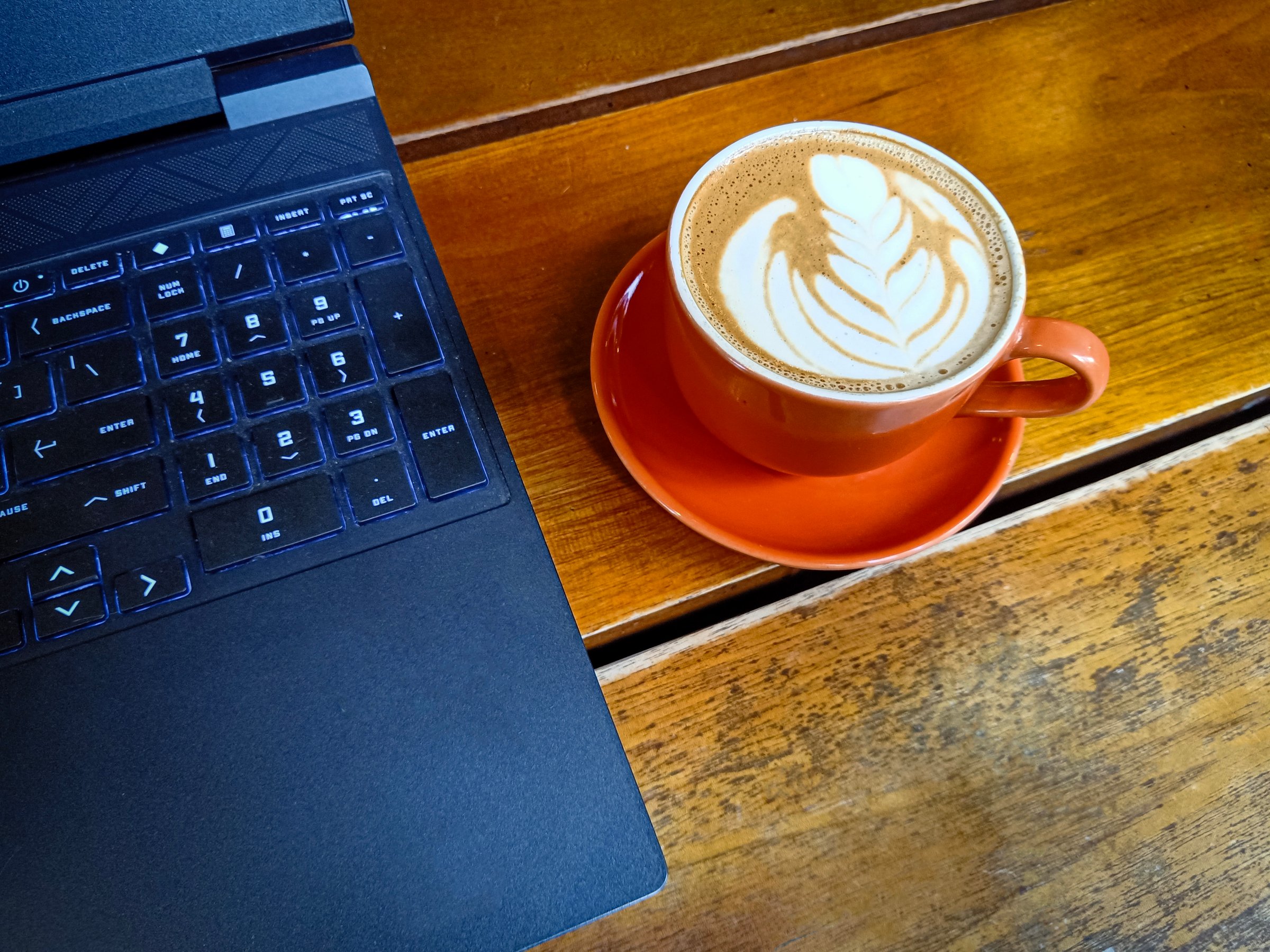 Cup of coffee on table with laptop. working at cafe concept.