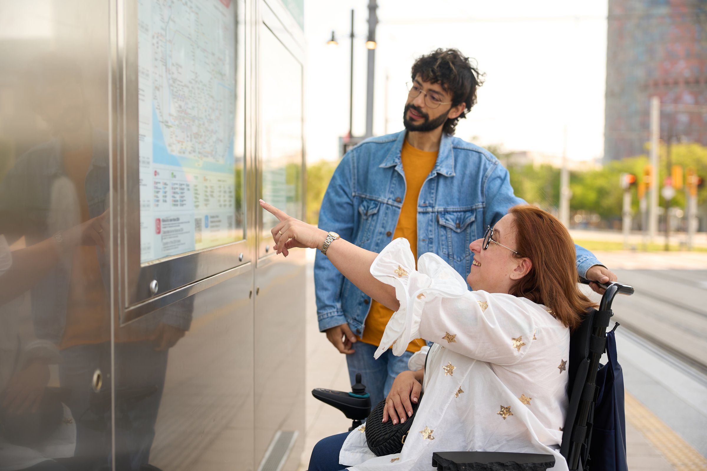 Woman using a wheelchair is pointing at a map
