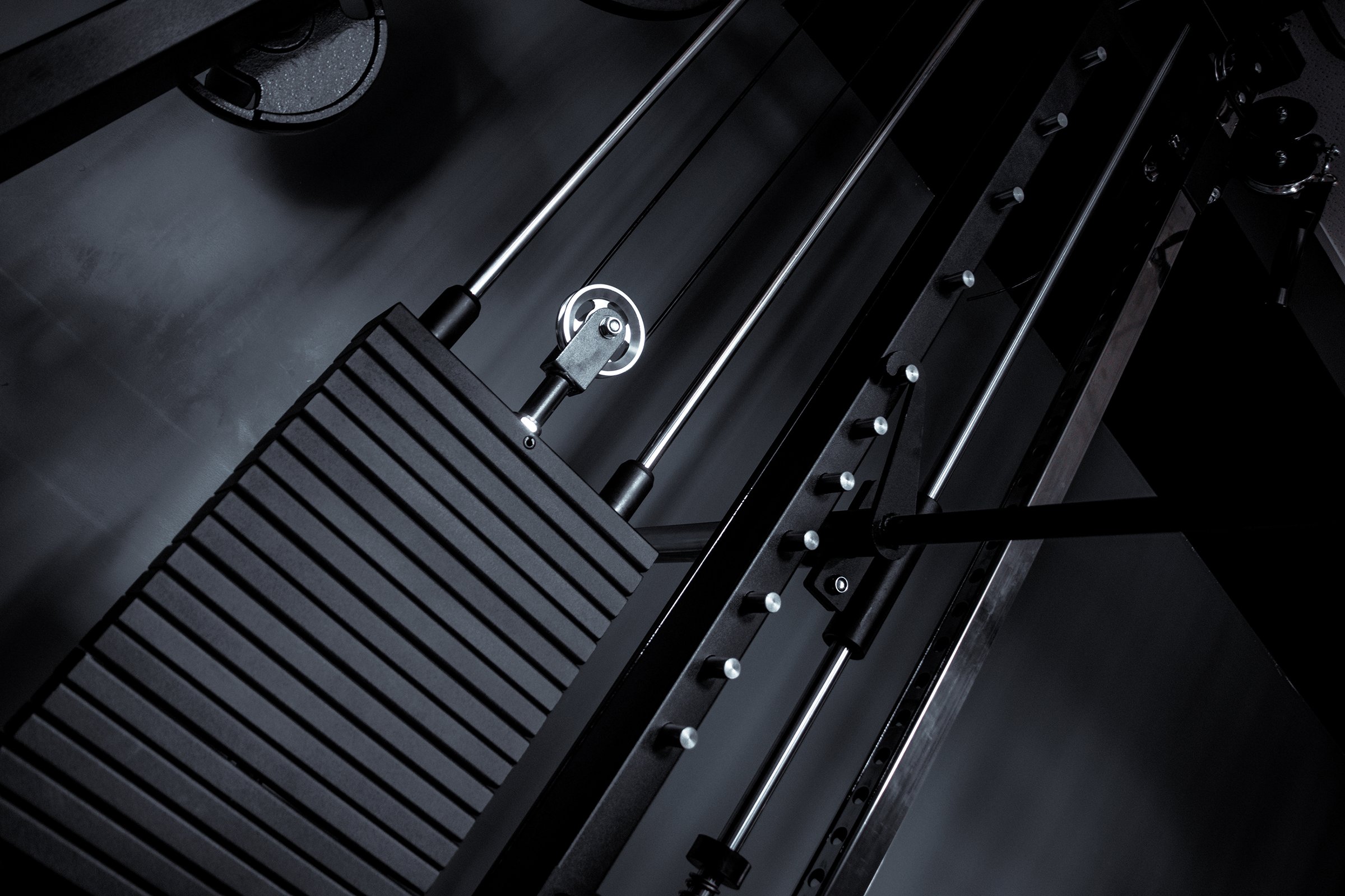 Private gym machine station at home closeup on pulley and weight black and white