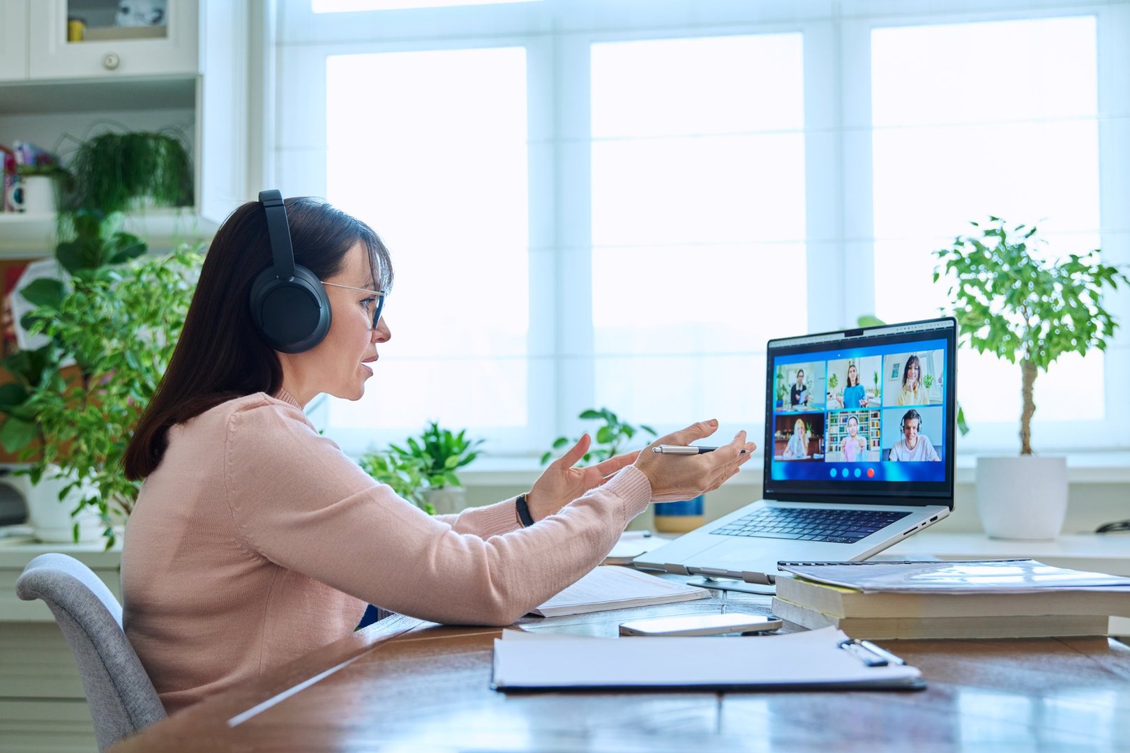 Woman teacher in headphones teaching online, high school students on laptop computer screen, video conference. Remote meeting, consultation, e lesson, training, education, technology concept