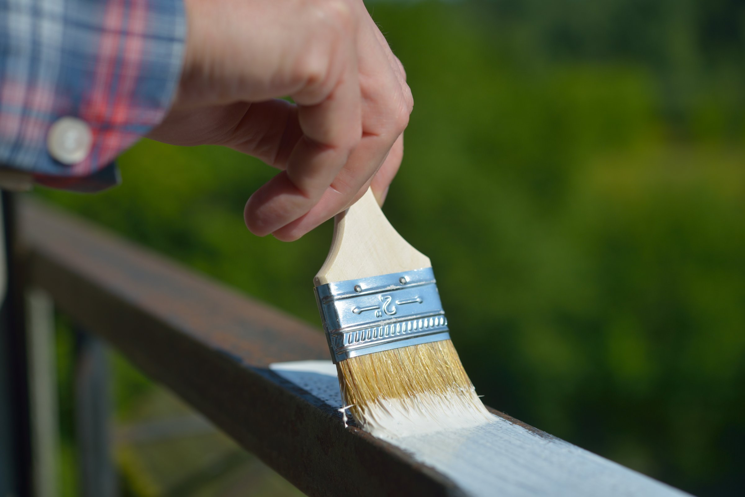 Man painting a guard rail on a balcony