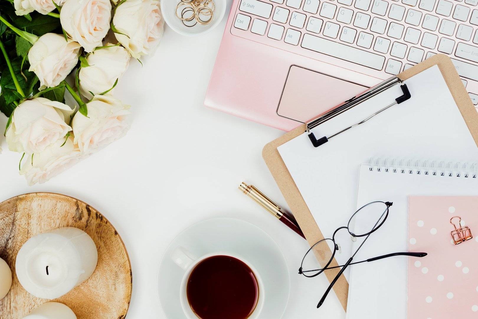 Stylish flatlay frame arrangement with pink laptop, tea, roses, glasses and other accessories on white. Feminine business mockup, copyspace