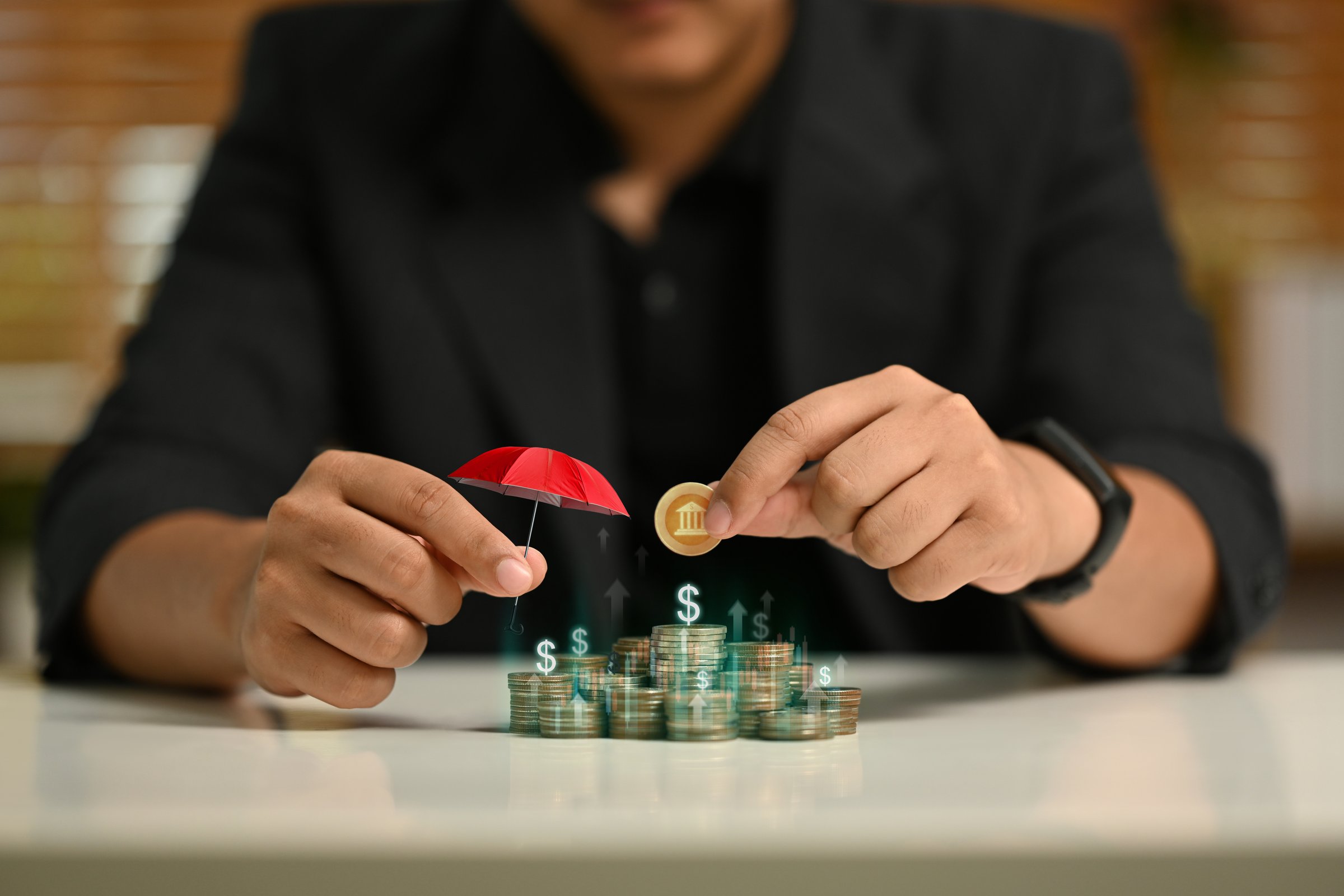 Businessman holding an umbrella over pile of coins. Personal finance, investment strategies and financial planning concept.