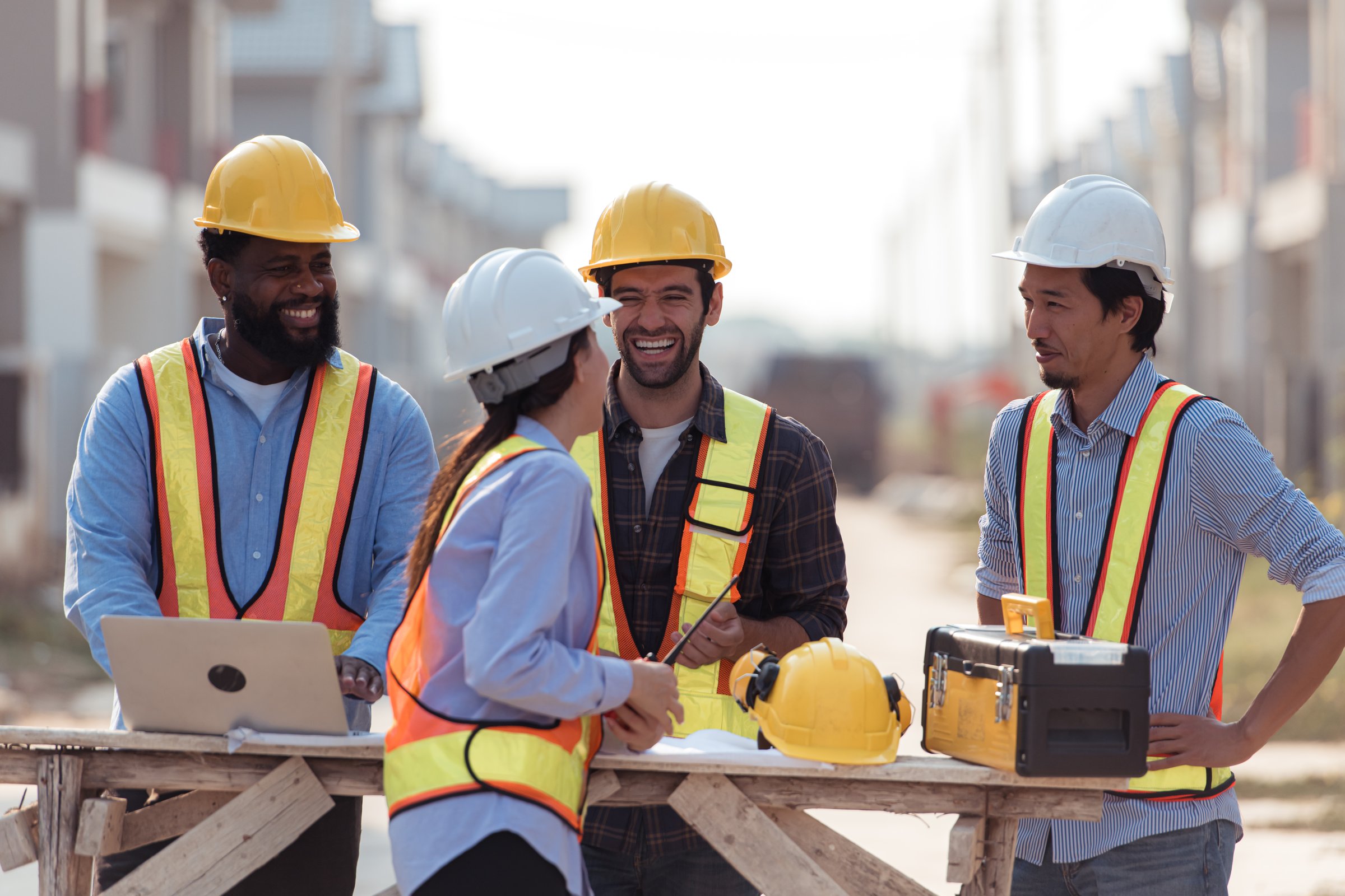 Group of architects and engineers work together to assess the residential home construction site's progress