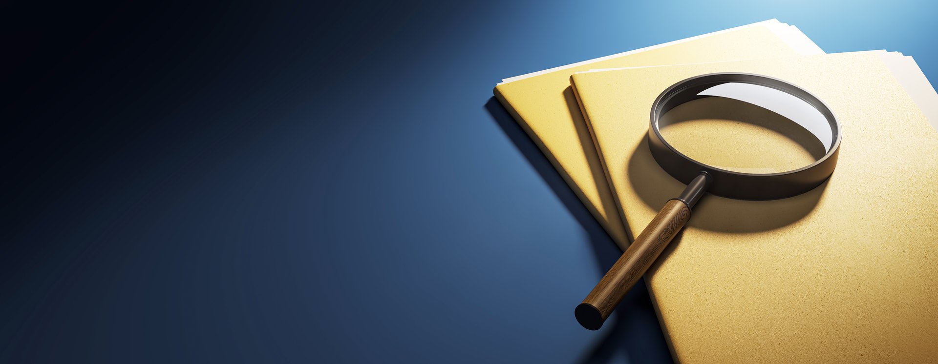 Magnifying glass on top of yellow folders on a blue desk background