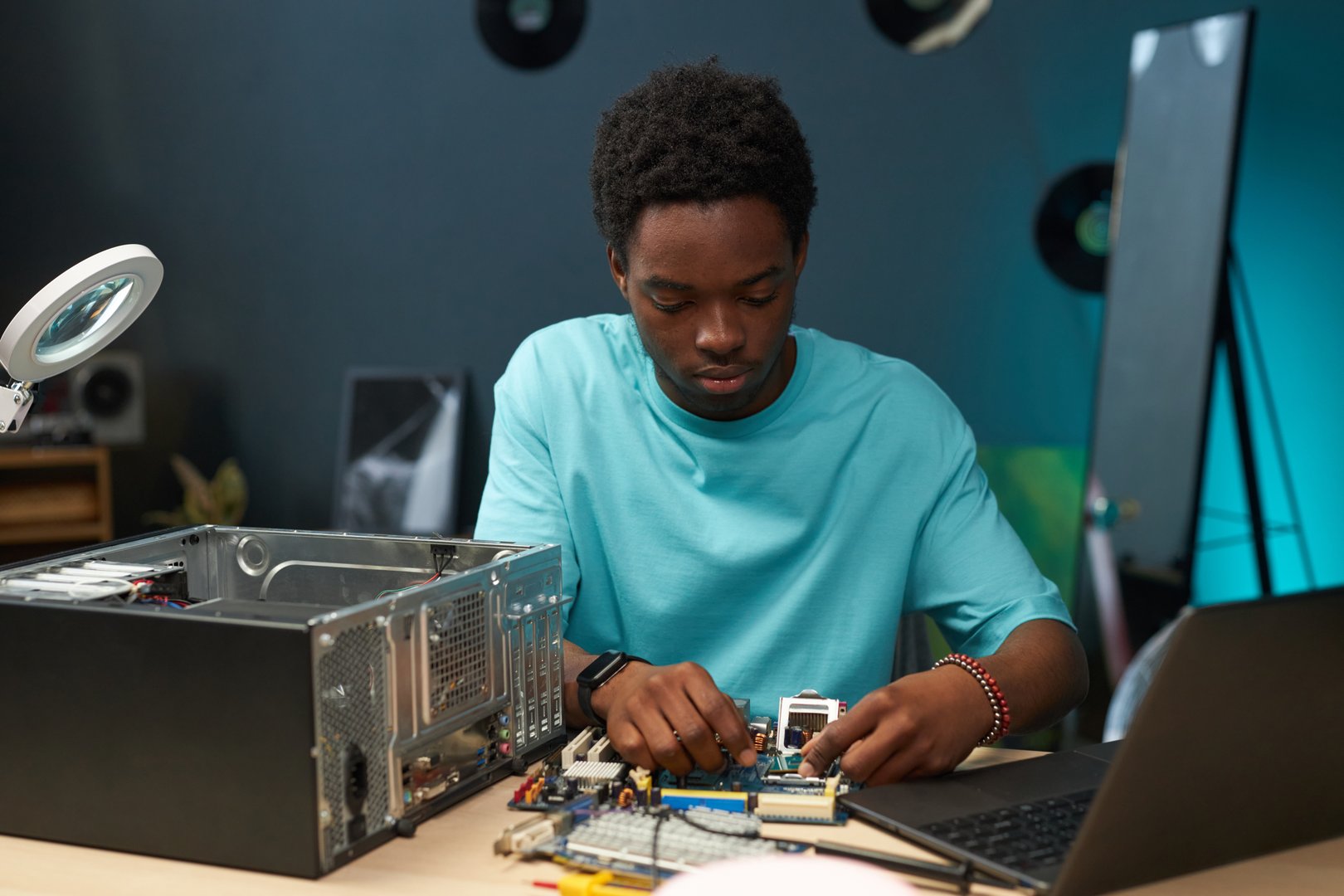 Young repairman concentrating on his work, he fixing computer components of motherboard