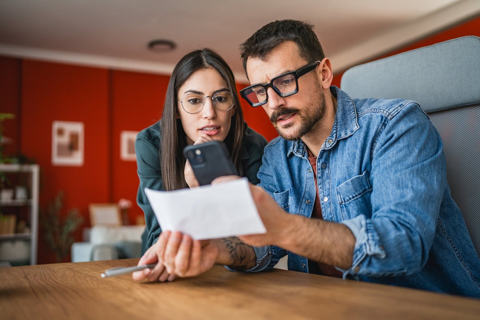man and woman couple pay bills at home have contactless payment on mobile phone