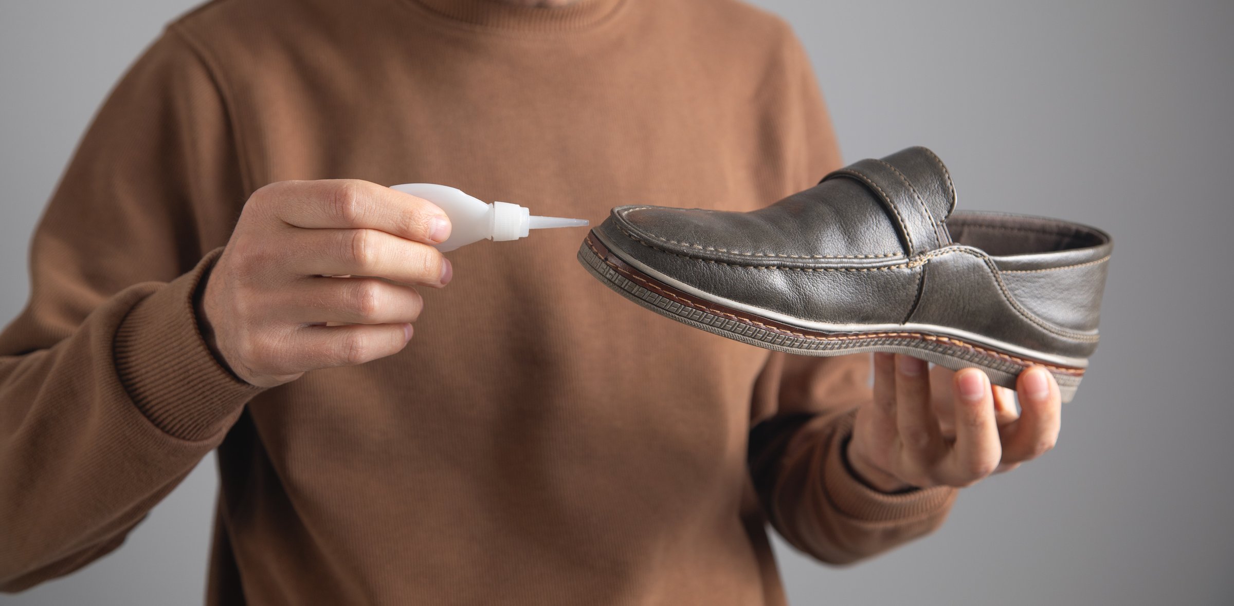 Caucasian man glues shoe. Repairing