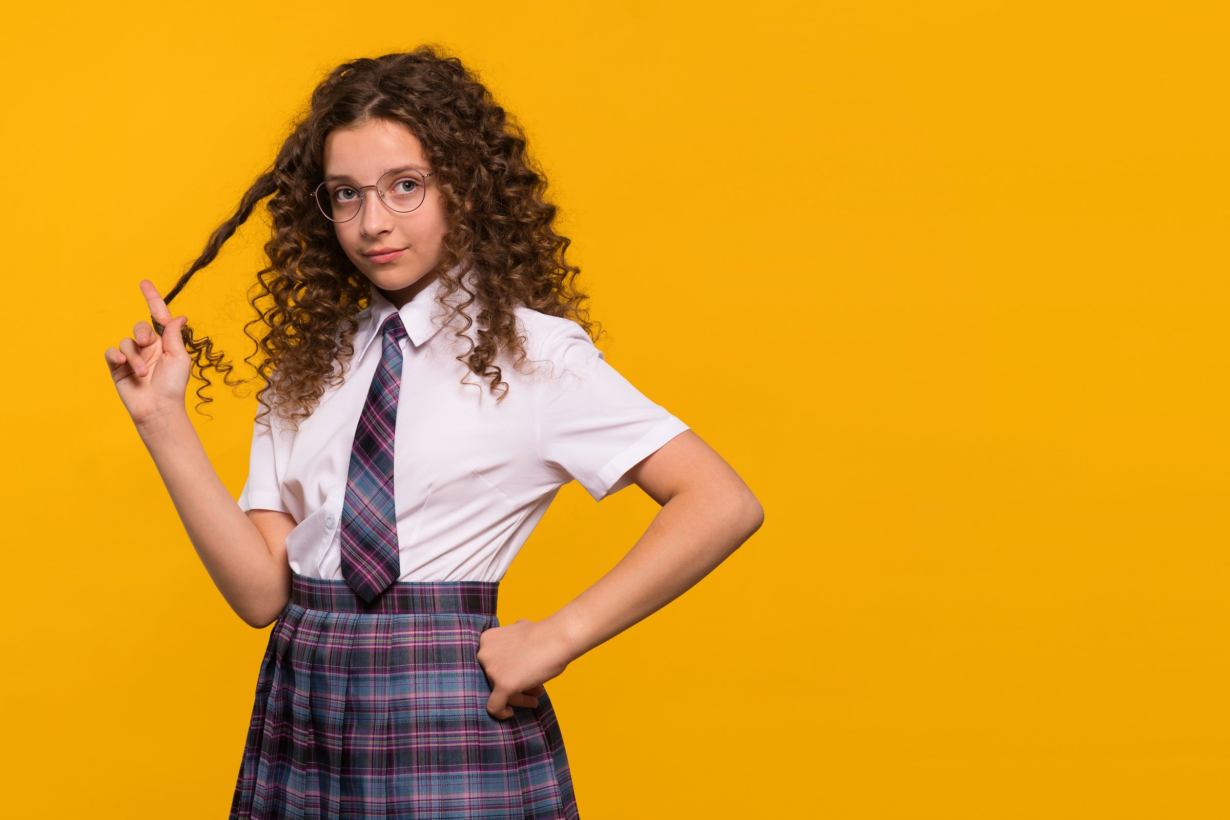 Girl twirling her hair, wearing glasses and school uniform.