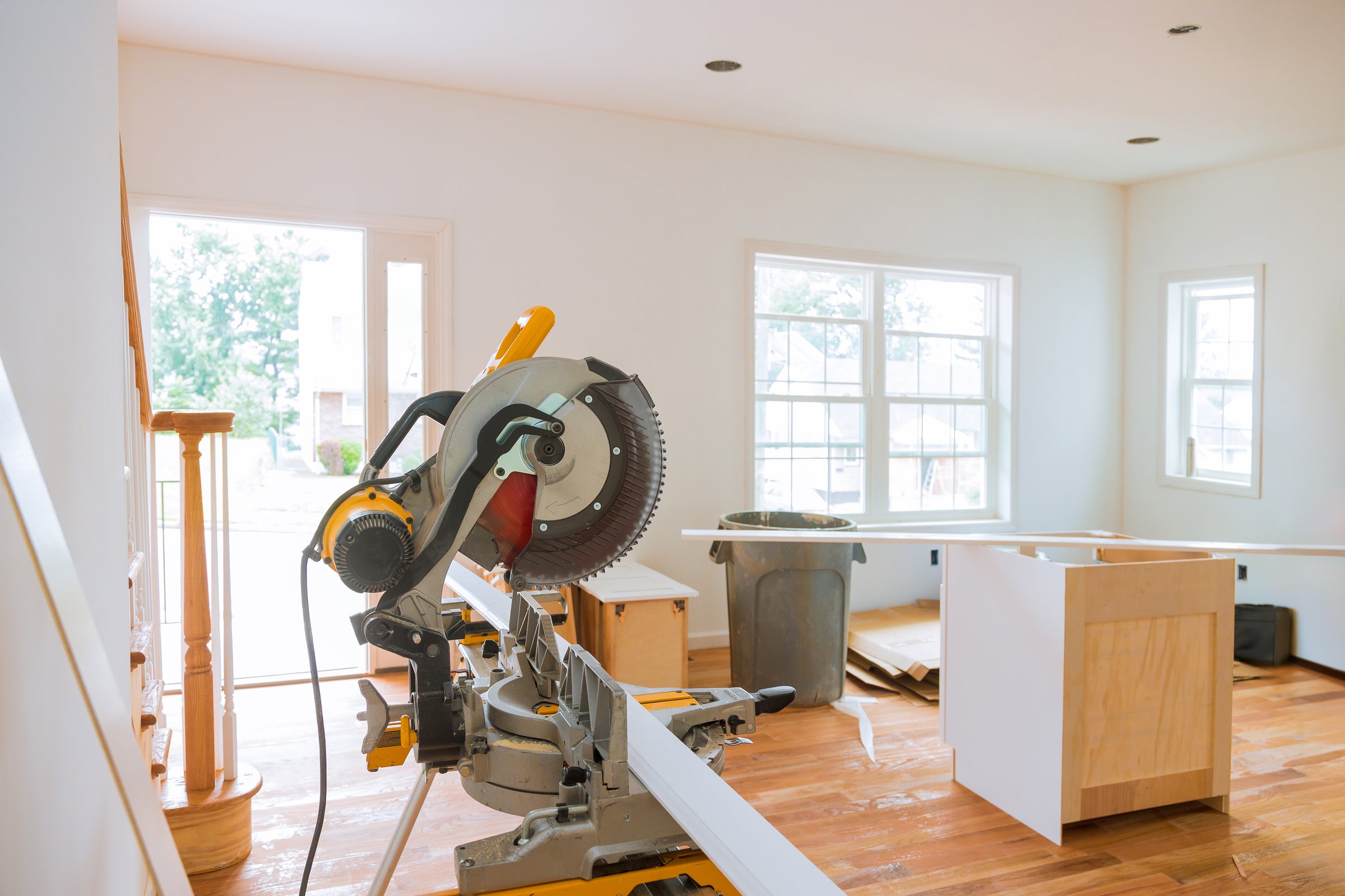 Room undergoing renovations features circular saw prominently displayed, surrounded by wooden materials tools, emphasizing construction cut trim molding