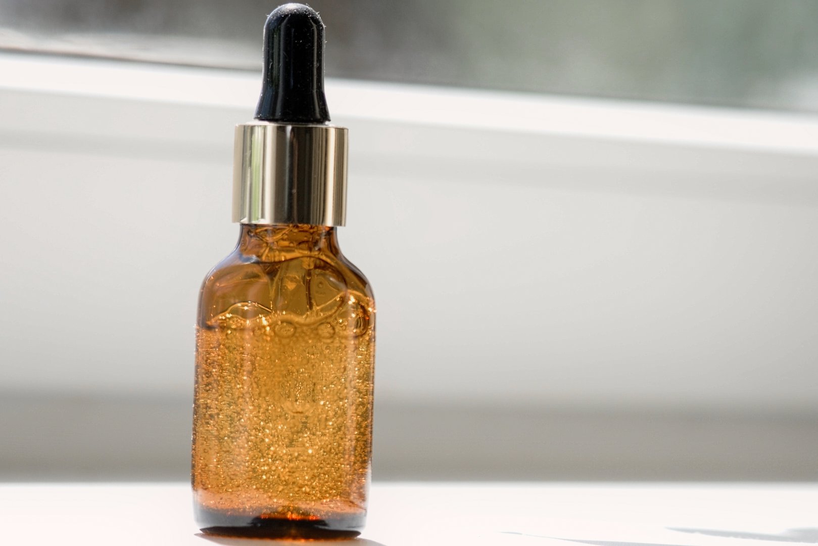 Natural oil cosmetics. Dropper glass amber Bottle Mock-Up. Oily cosmetic pipette. Face and body treatment. Spa concept. Mineral organic liquid. Front view. Beauty products. Blank packaging on white. Trendy glass bottles with oil on white background. Transparent cosmetic bottles on geometric podium. Blank branding mock-up. Natural beauty product. Minimalism. Herbal medicine. Wellness. 3D. Eco Bio cosmetic products