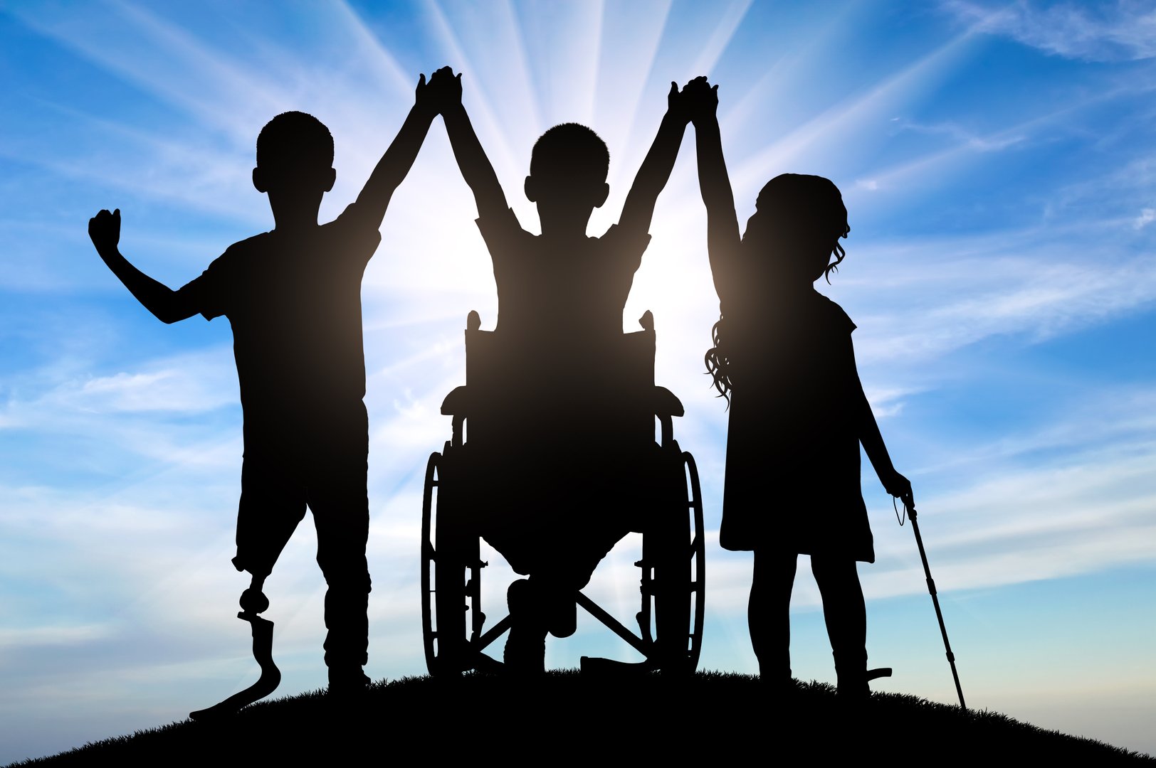 Silhouettes of three children with different disabilities standing together holding hands. Concept of strength and unity of children with disabilities, promotion of inclusion and support.