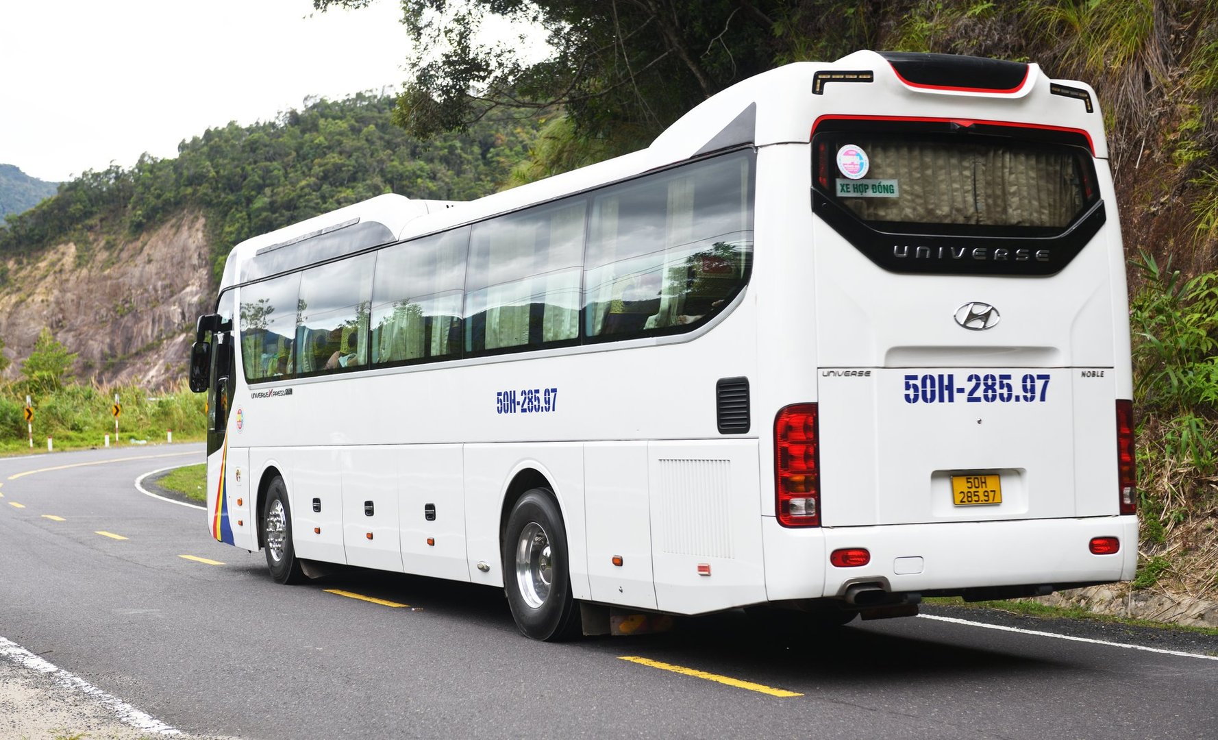 Vietnam Danang 07.13.2024:a Hyundai Universe bus are driving along a mountain road.