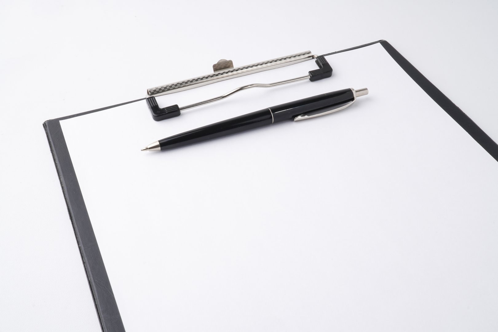 A close-up photo of a black clipboard and a classic pen to writing something on a blank white sheet of paper. Isolated on white background.