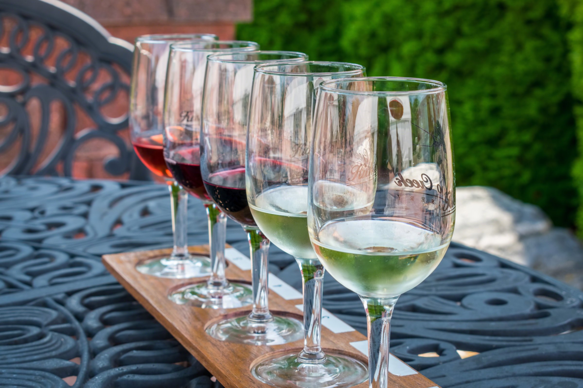 Wine tasting flight lined up on outdoor table at local vineyard
