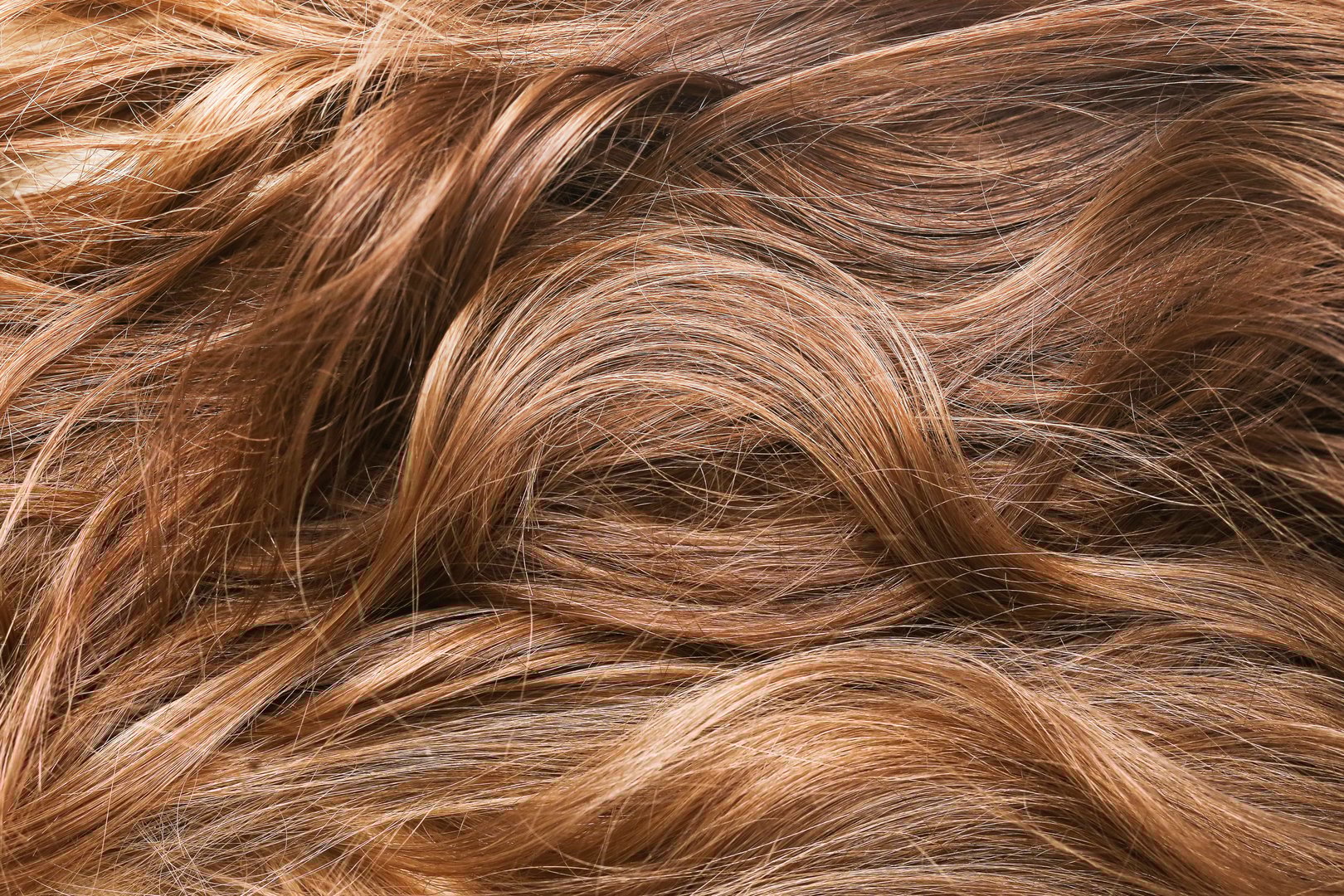 Beautifully styled brown hair with natural shine and soft curls. Wavy hairstyle pattern.