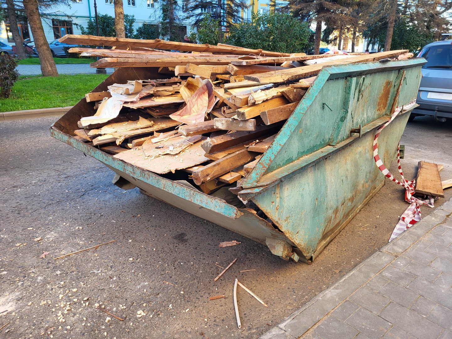 Green waste skip bin filled with debris