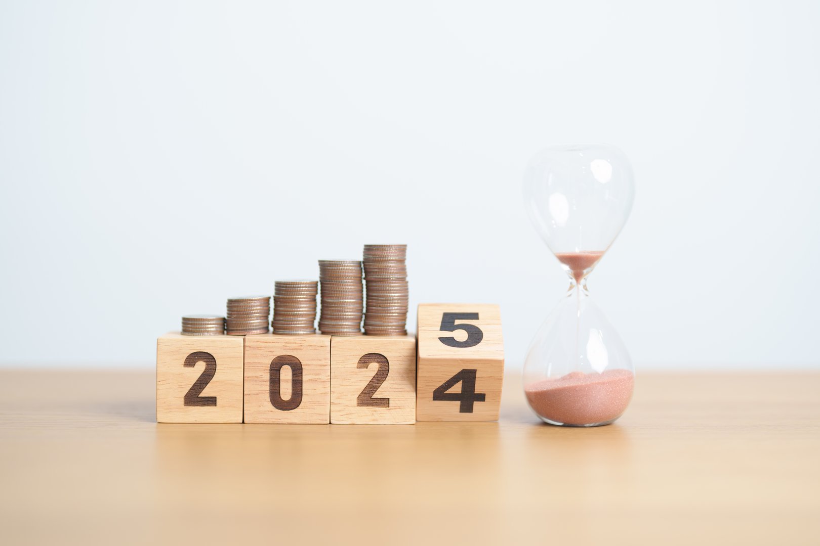 2024 end year to Happy New Year 2025 with hourglass and coins stack arrangement. Money Saving for Future Plan, Retirement fund, Pension, Investment, Wealth Business, Financial and countdown concepts