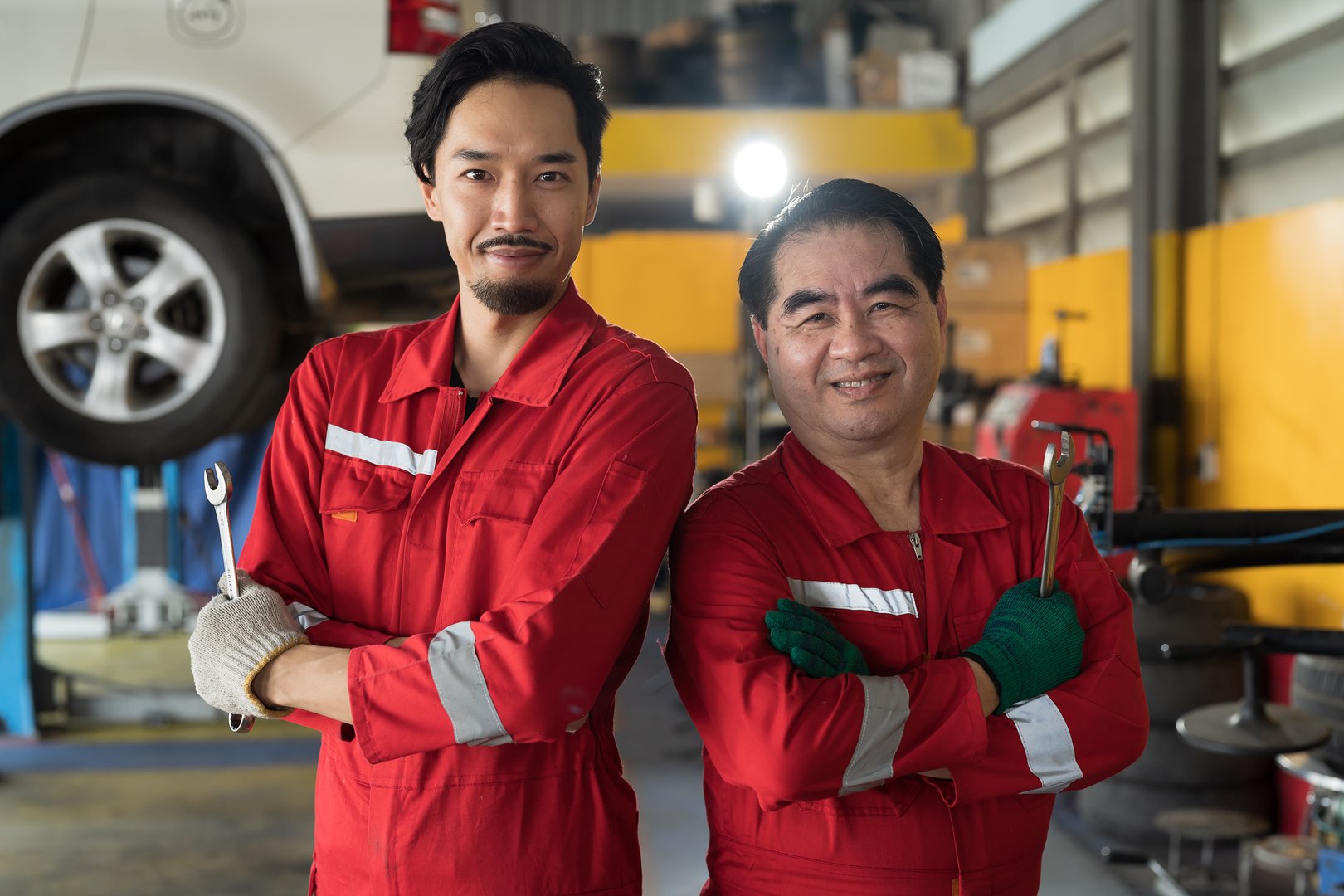 Portrait of team of Asian male mechanic working at car garage. Group of Asian male mechanics at auto car repair service
