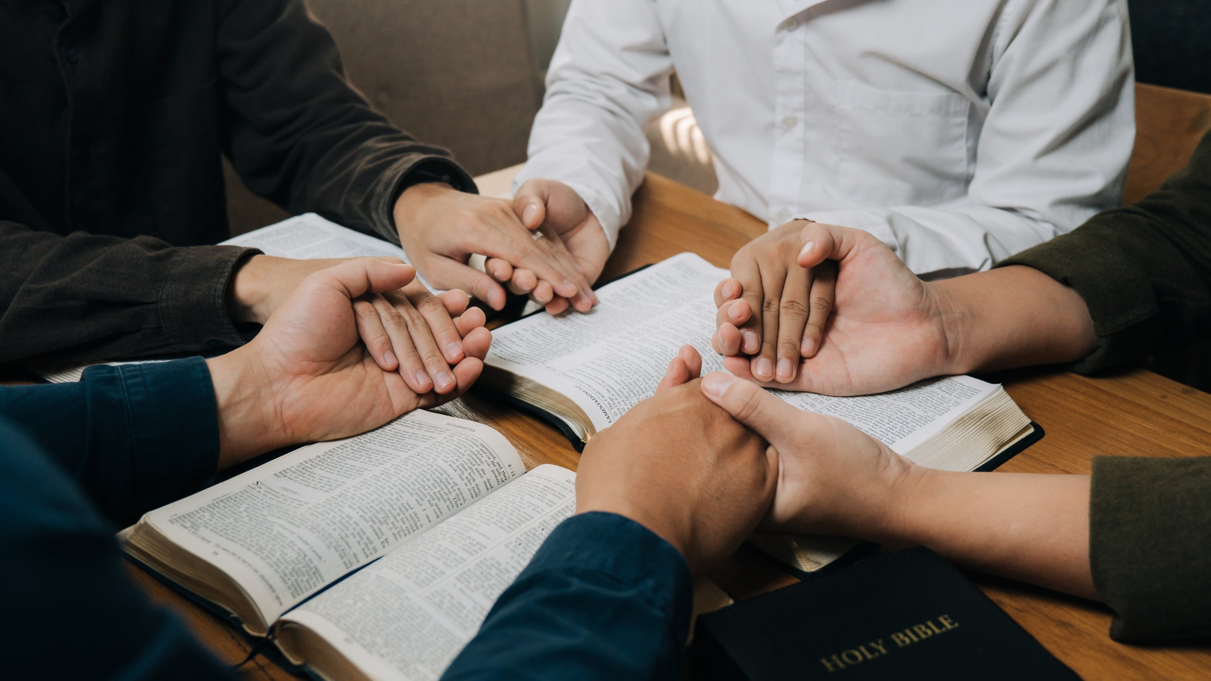 Christian group holding hands pray and worship god together on the sunday morning.spirituality, religion,believe.Christian life.Studying the word of God in church.