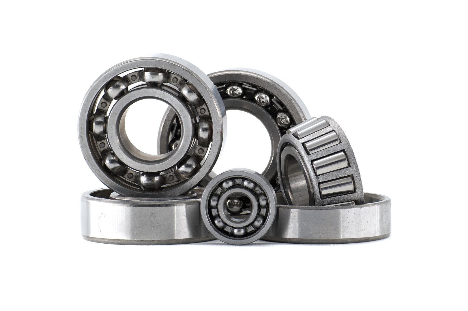 Various types of metal bearings including ball and roller displayed against white background. Mechanical components essential for industrial machinery reducing friction and ensuring smooth motion