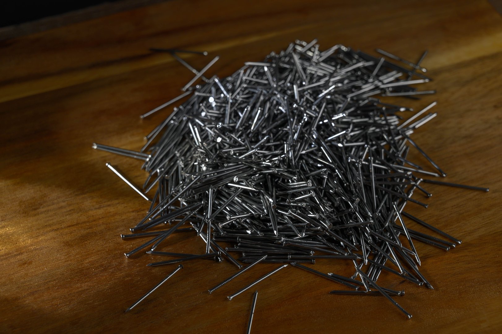 A pile of small nails on a wooden table
