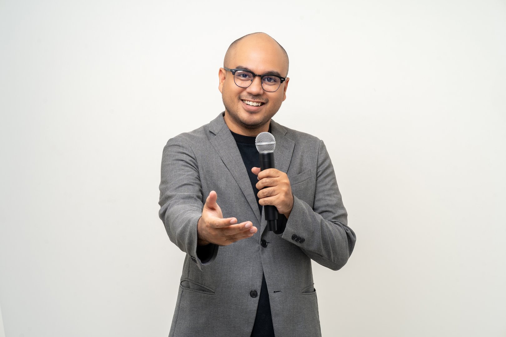 Businessman speaker with high quality dynamic microphone speaking talking with people on isolated white background. Male testing microphone voice for interview. Motivation life coach in training