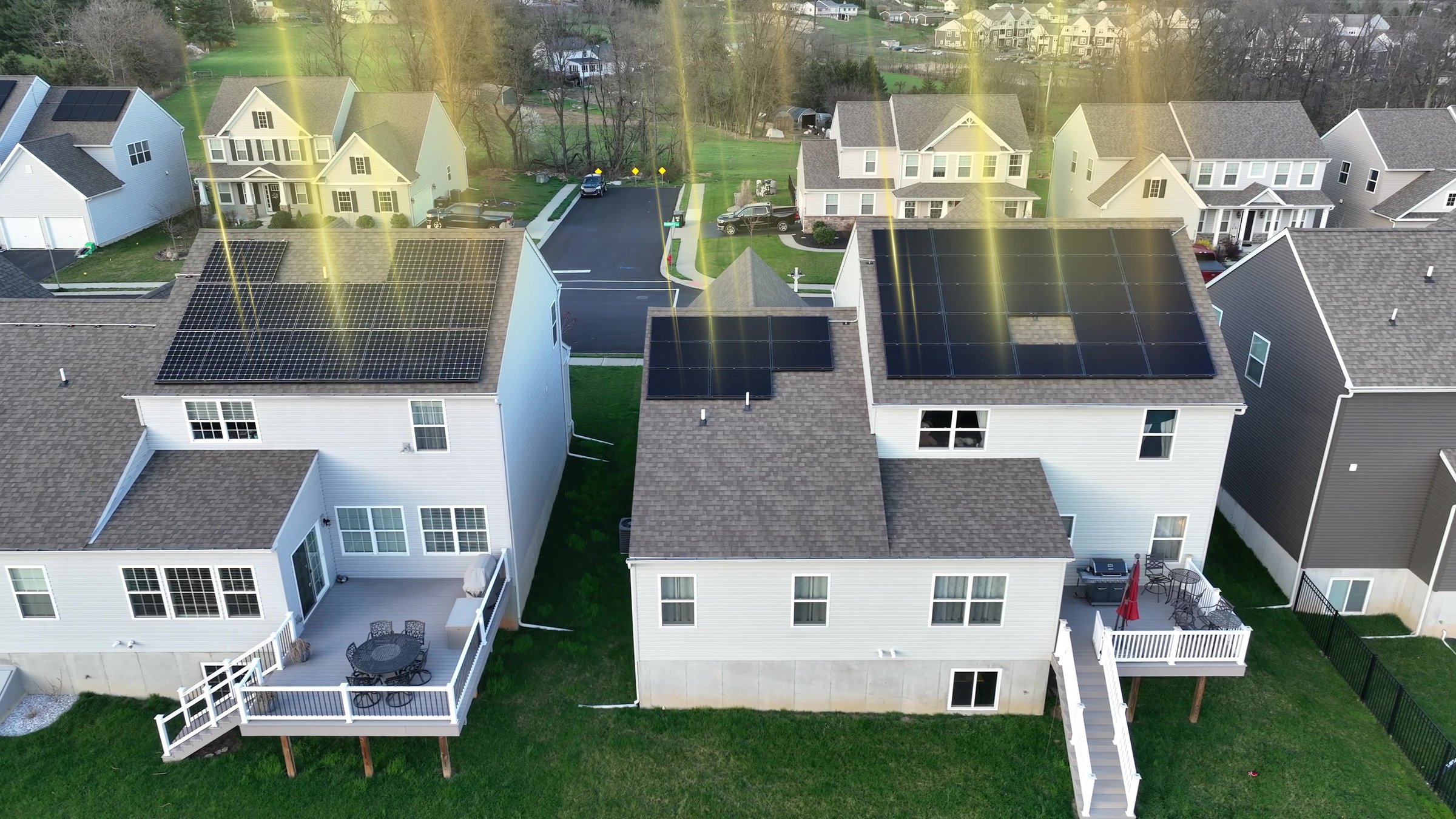 Animated golden sun rays shining on rooftop solar panels in modern American neighborhood. Renewable energy generation through photovoltaic array. 3D render. Aerial