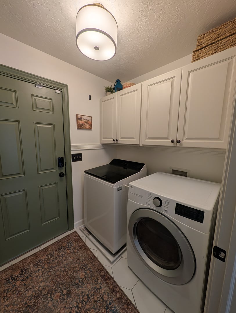 Organized laundry room with cabinet storage and functional decor
