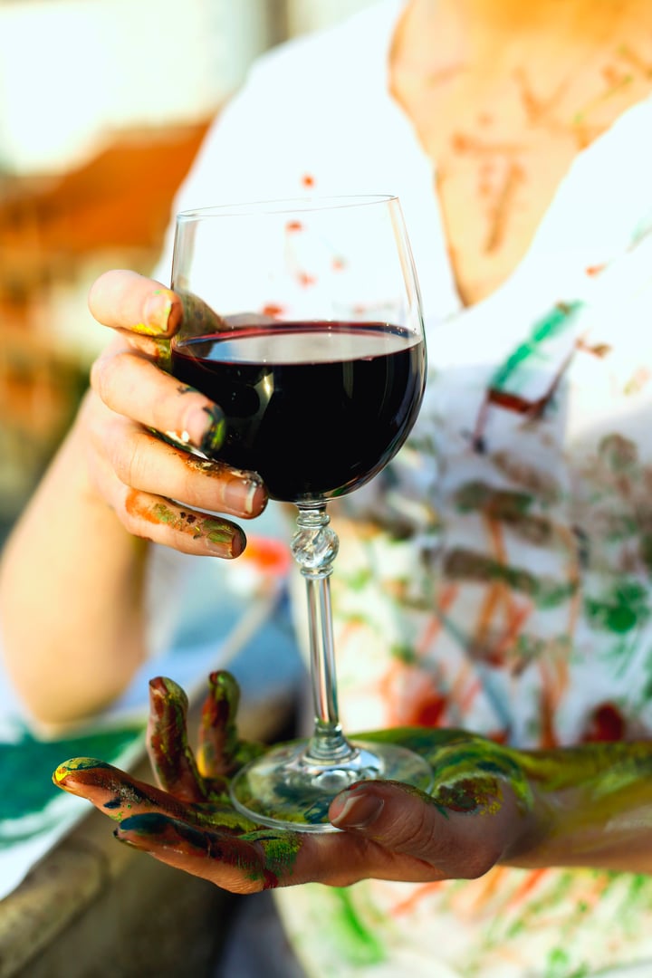 Young artistic woman with red wine in hands