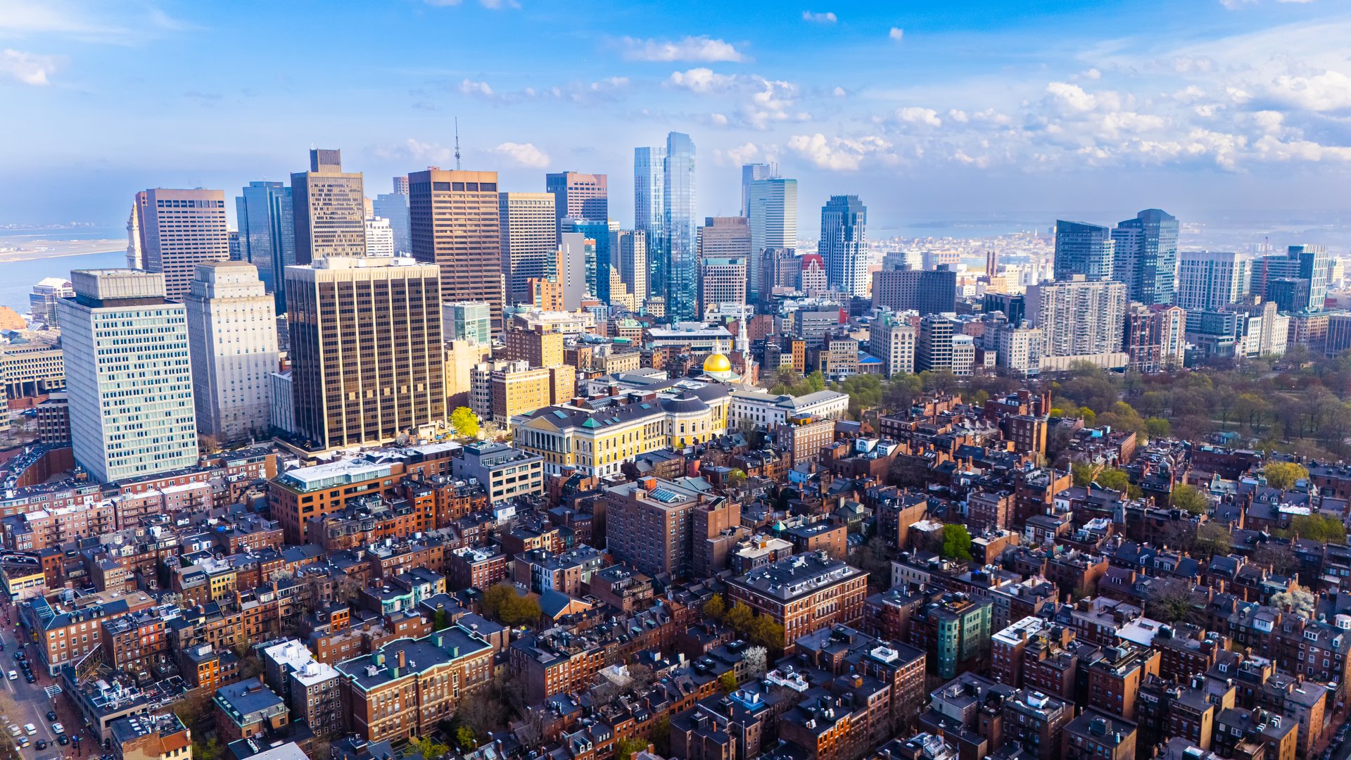 Orange brick houses along stunning skyscrapers. Varied scenery of Boston, Massachusetts, USA. Aerial view.