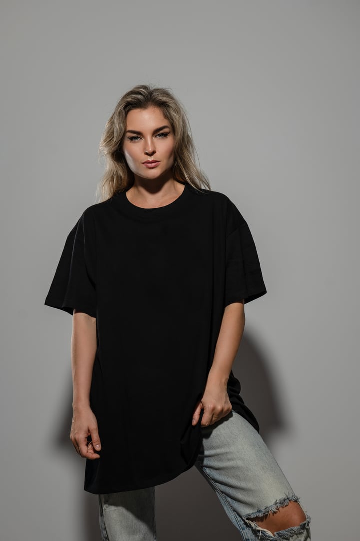Confident Woman Wearing Oversized Black T-Shirt with Blank Space for Mockup.