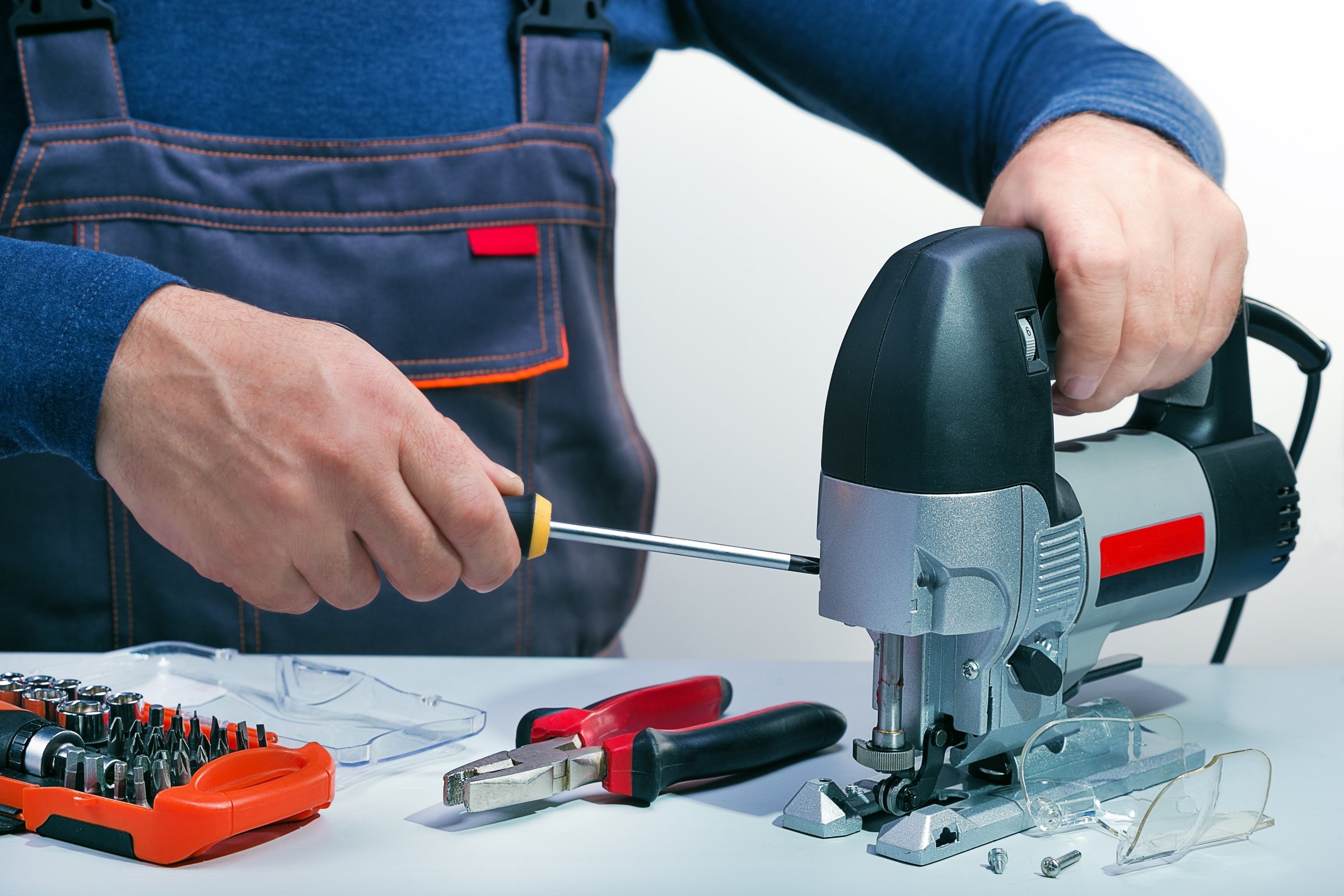 Professional technician working in repair shop. Repair, service electrical tools, power tools. Small business.