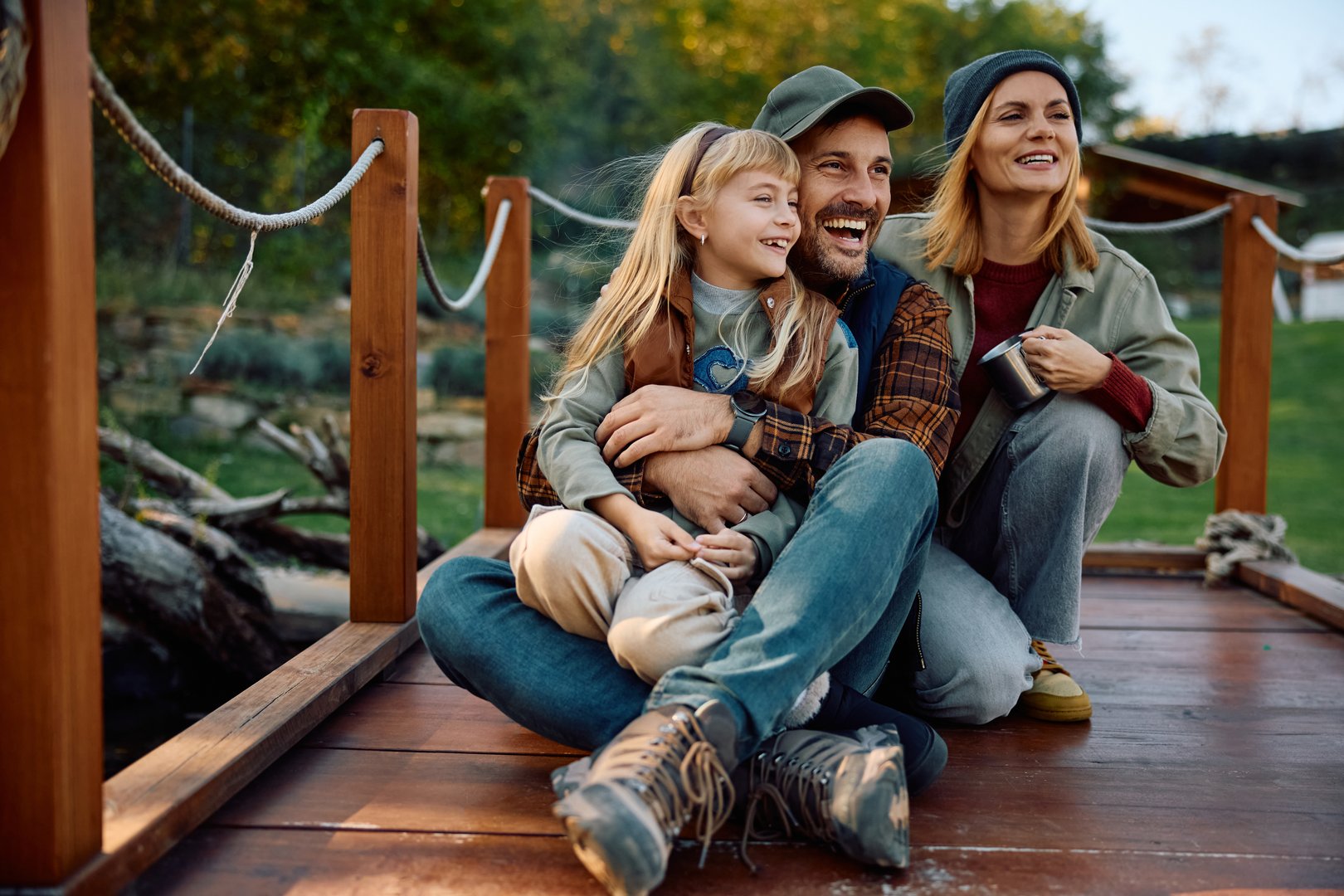 Happy family enjoying while relaxing on a pier in nature.