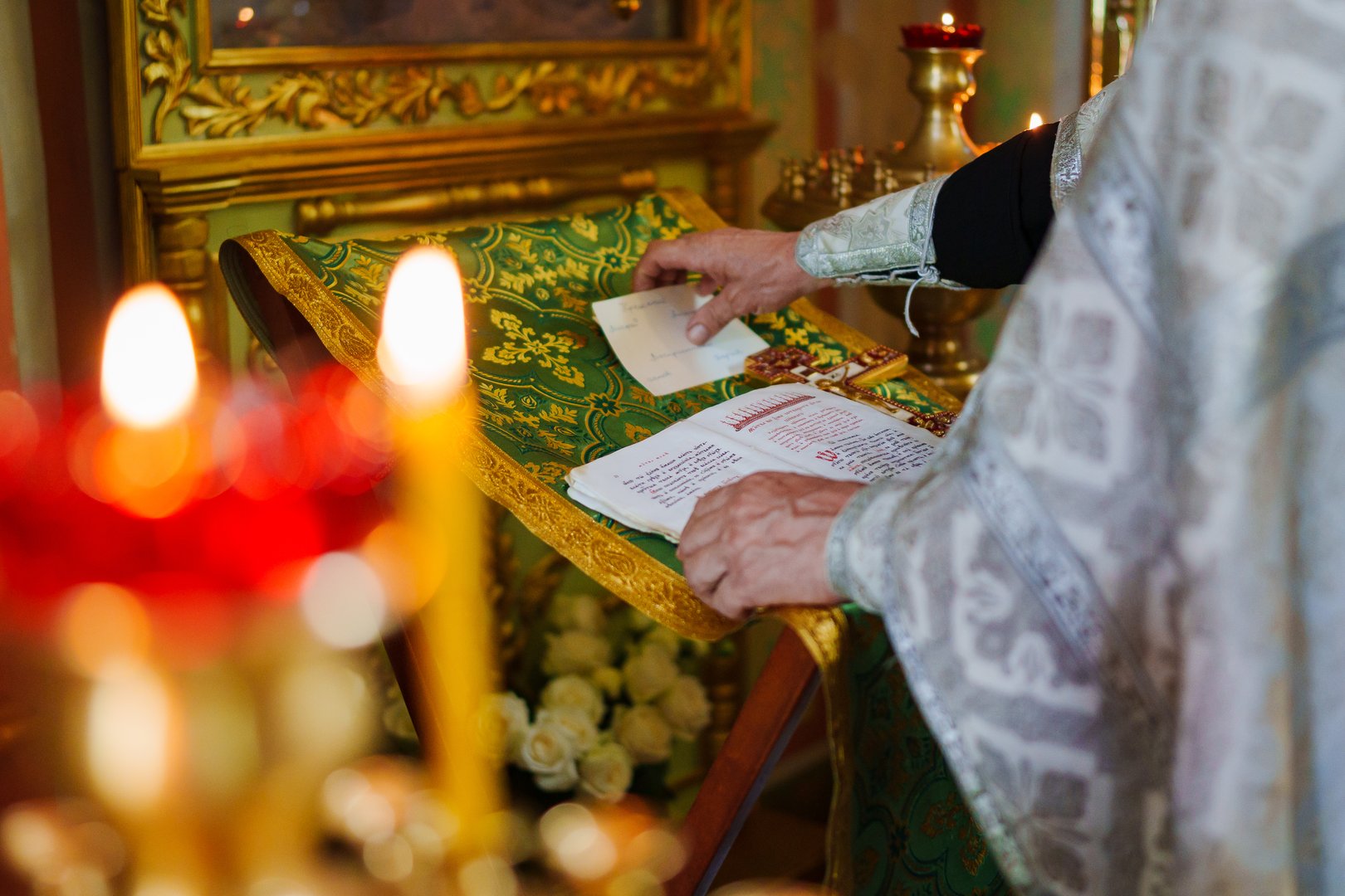 without a face. A priest with a prayer book on a table conducts the service. The concept of faith in God and the beauty of the interior of Orthodox churches.
