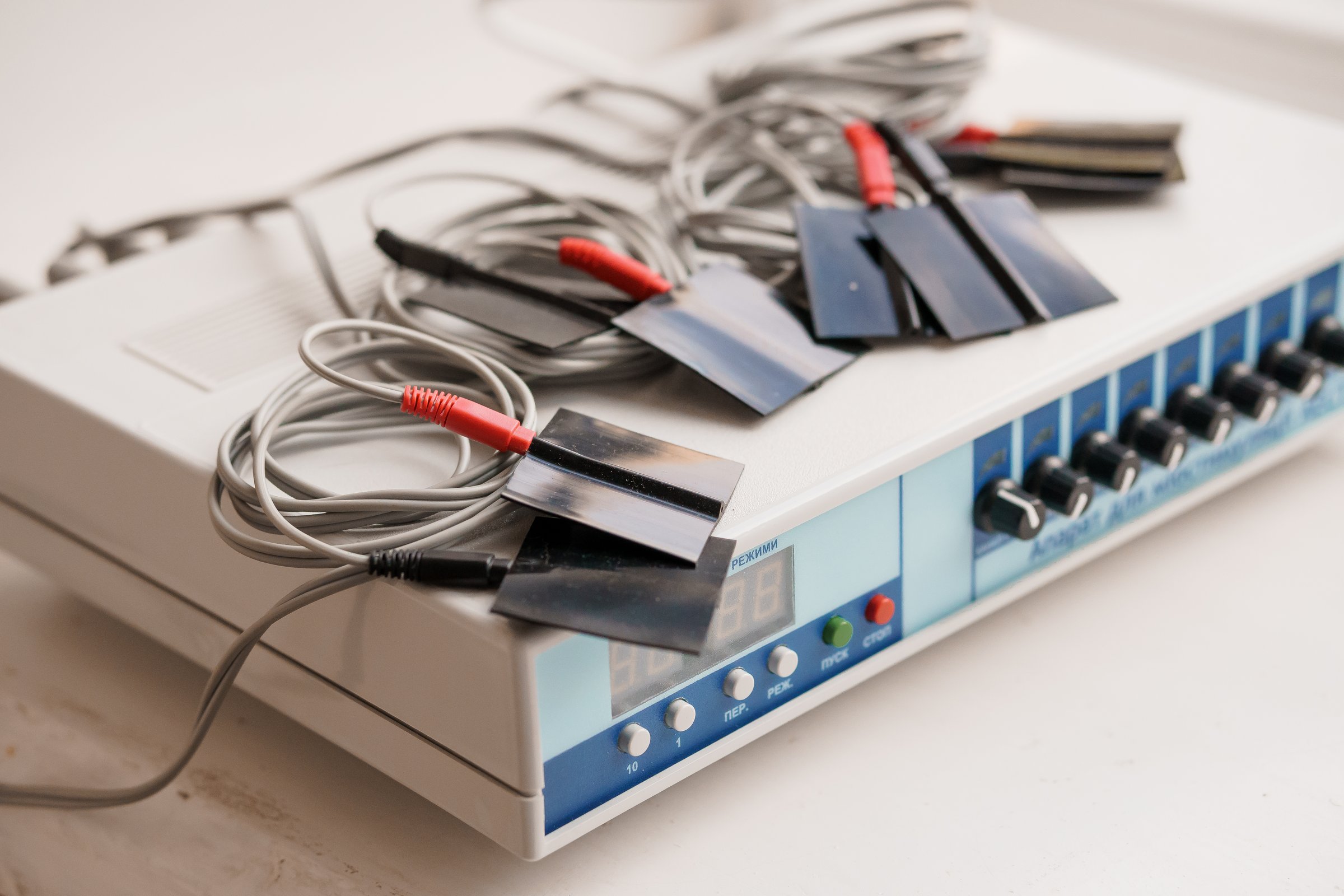 Medical Electrotherapy Device with Electrodes and Wires.