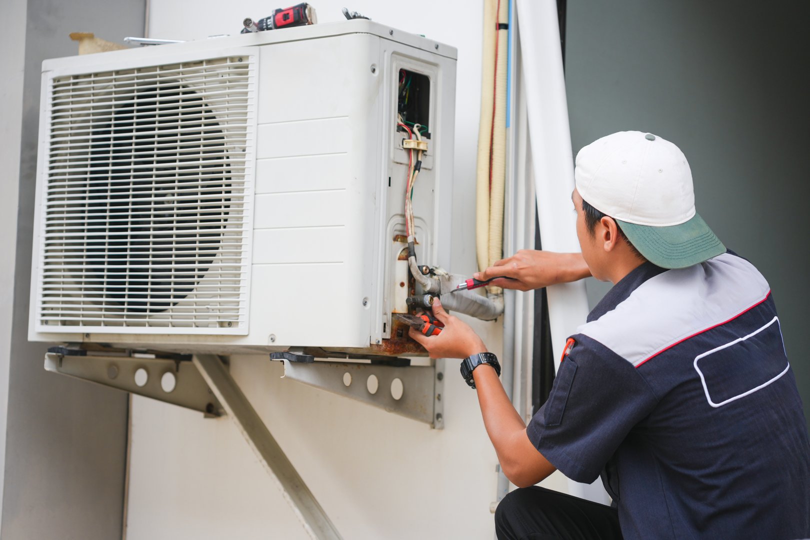 Repairman fix air conditioning systems, Male technician service for repair and maintenance of air conditioners