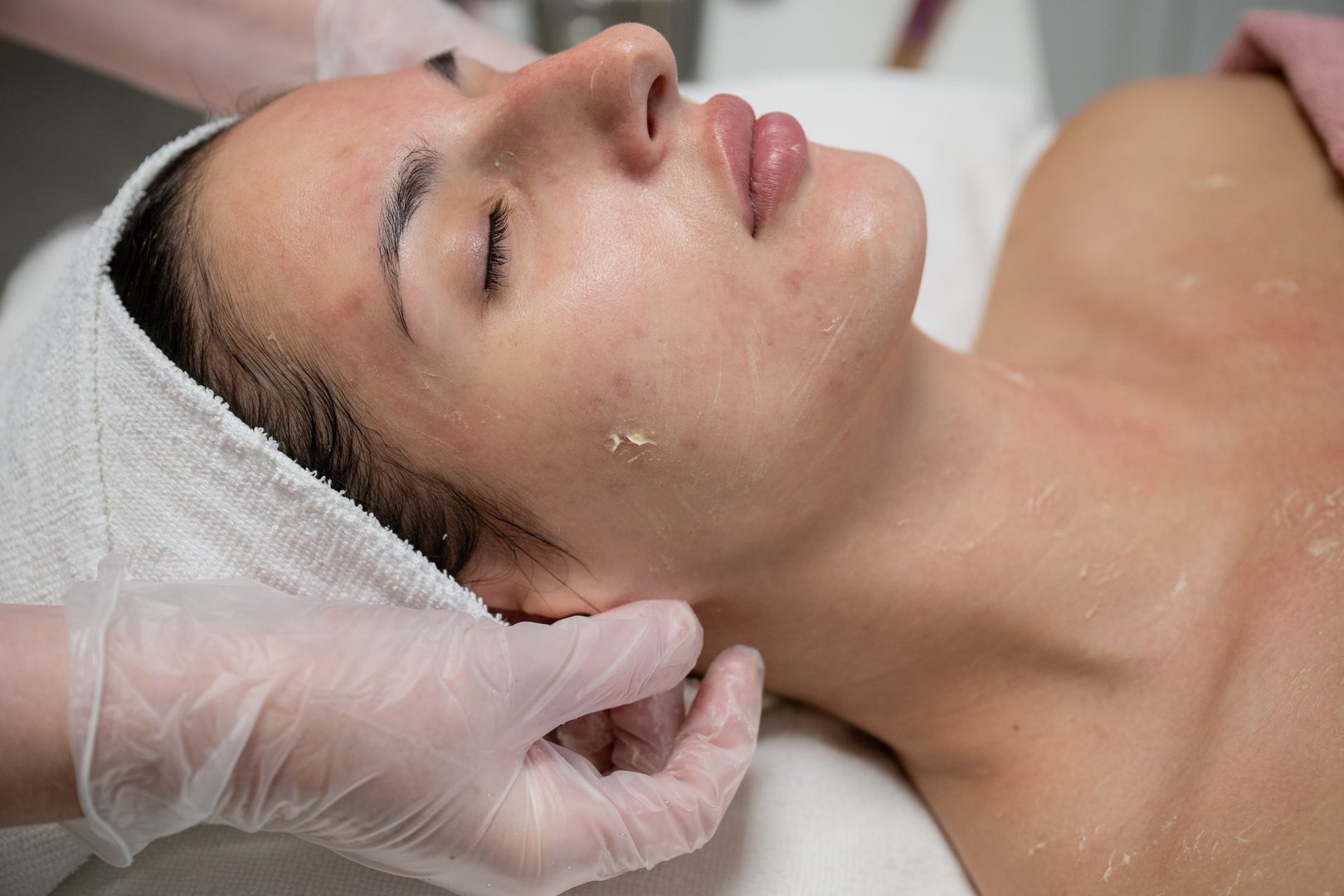 Beautician performing facial skincare treatment for female client in beauty salon