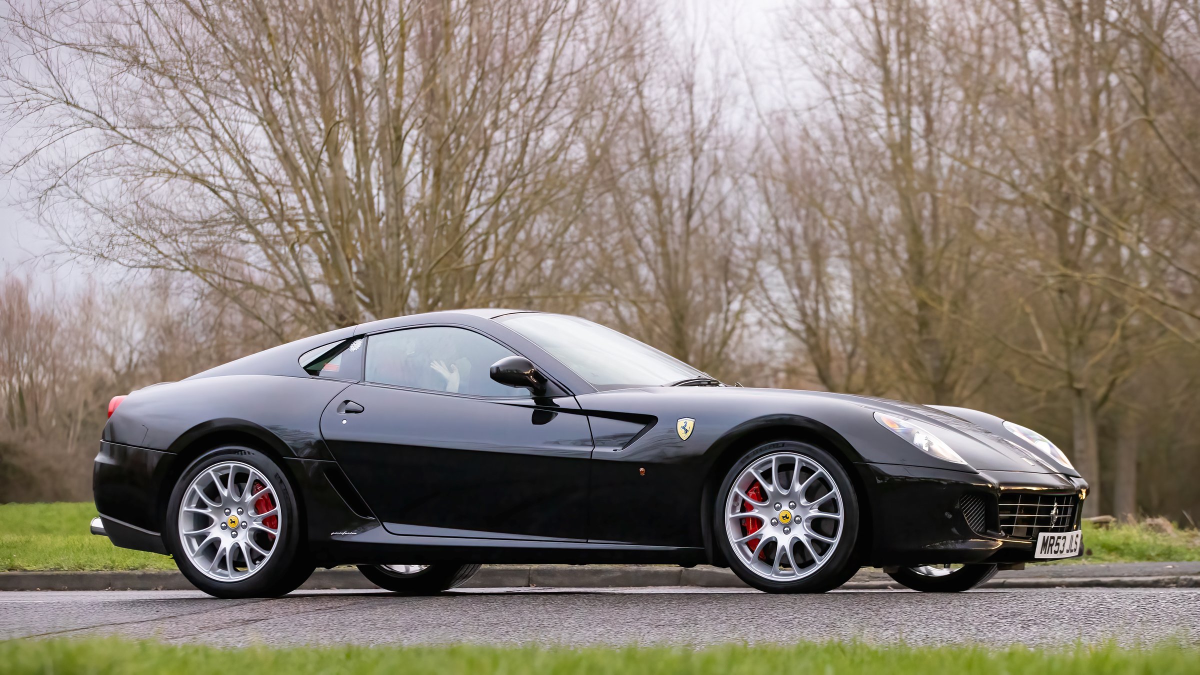Milton Keynes,Bucks,UK - Jan 1st 2026: 2008 black Ferrari 599 classic car driving on a British road