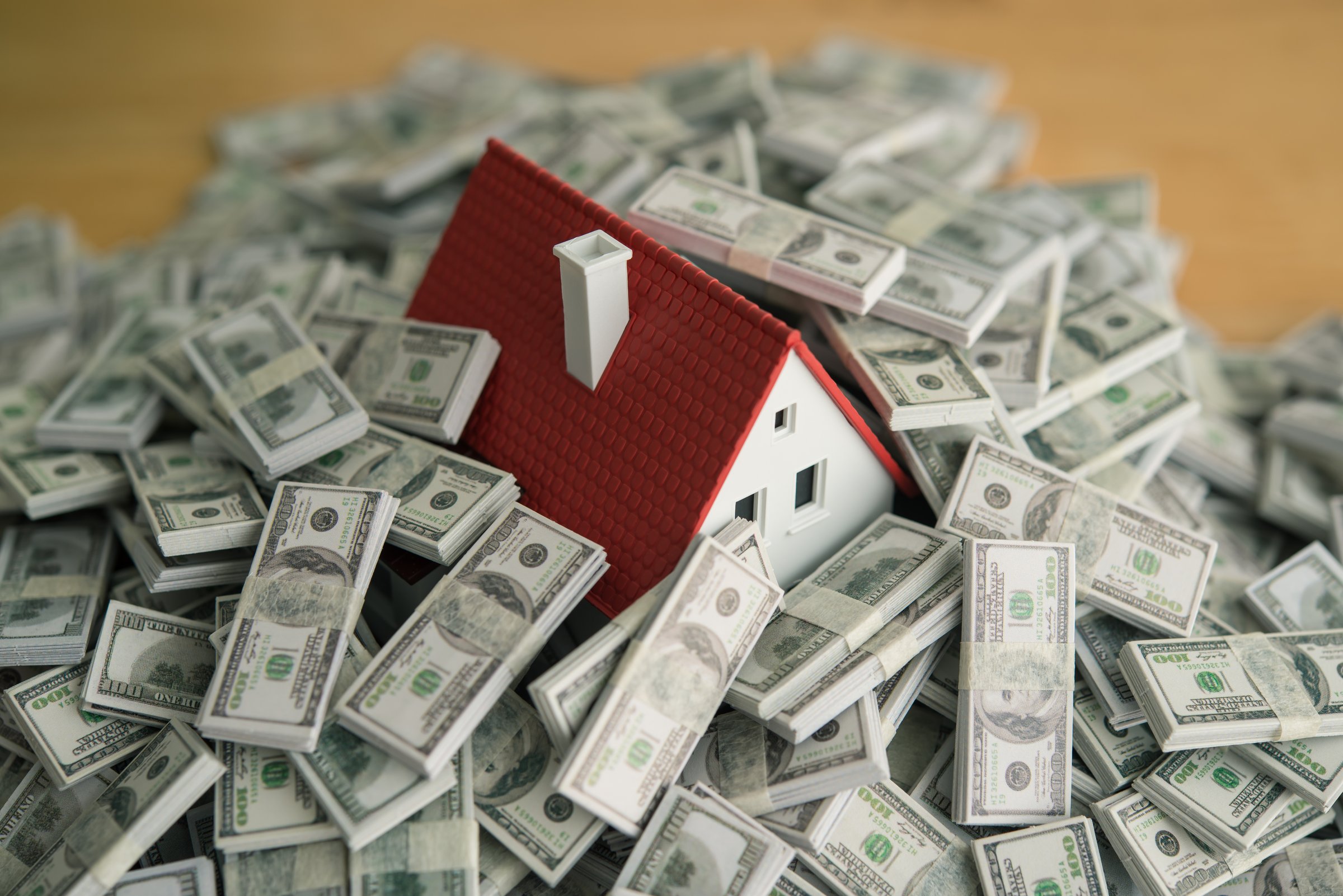 A house drowning in heap US dollar banknotes. Debt from buying home or real estate property, mortgage loan high interest rate, FED central bank control monetary policy of interest rate, banking and so on concept.