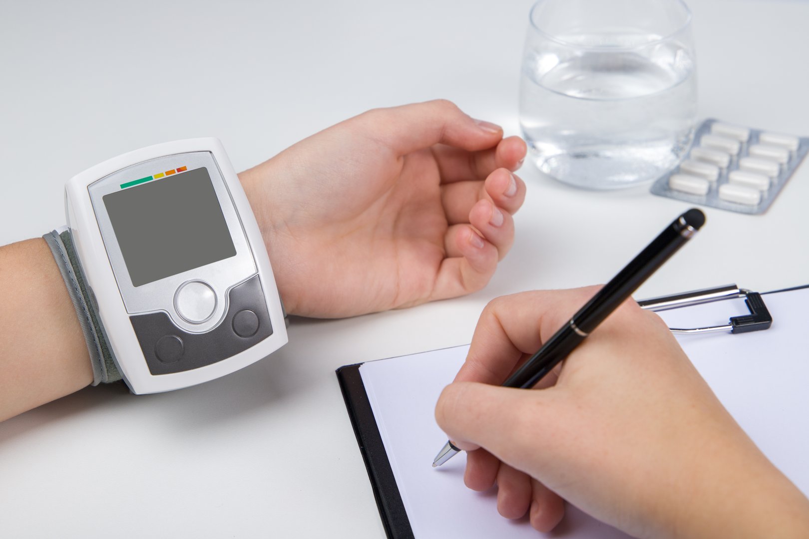 Woman checks blood pressure with a tonometer. Automatic tonometer on the wrist