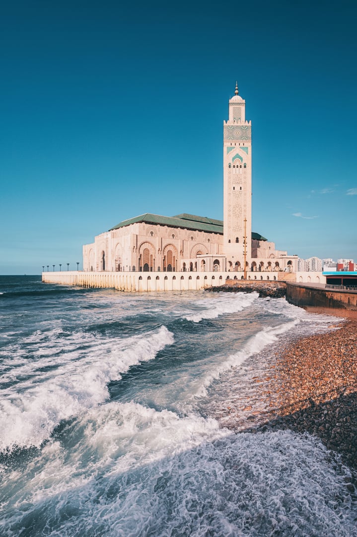 Ocean waves crashing against the Hassan II Mosque in Casablanca, Morocco, a stunning display of architecture and nature