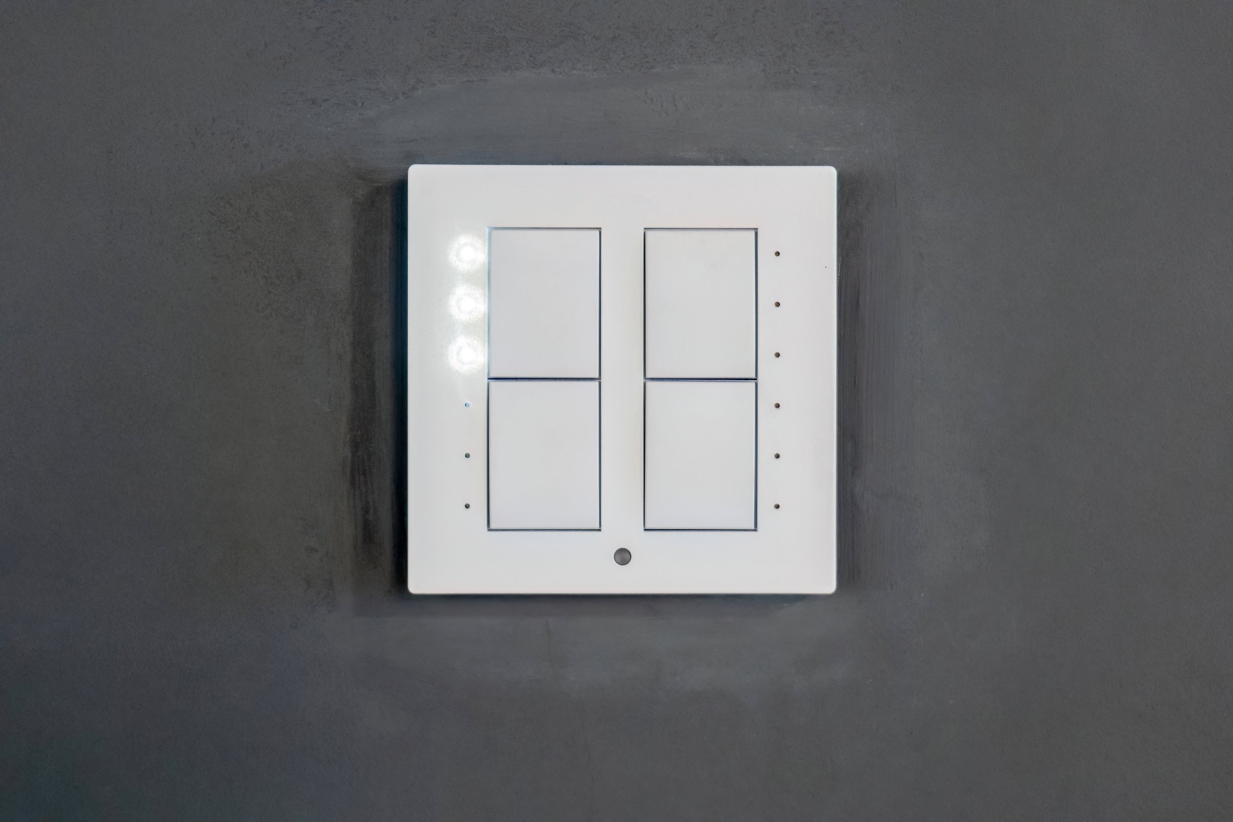 4 button white modern smart light scene switch on a grey wall, object front view, frontal shot, building interior detail nobody Switching lighting scenes in a smart home setup multiple devices control