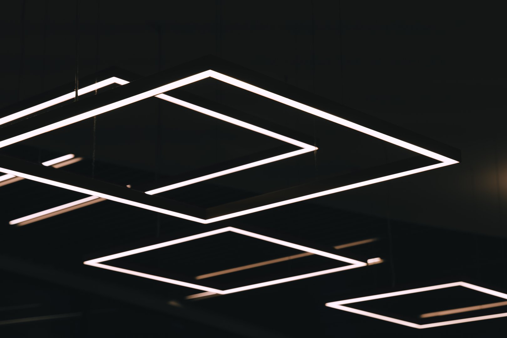 A close-up of a ceiling fixture, with multiple rows of white, rectangular lights, creating a geometric pattern.
