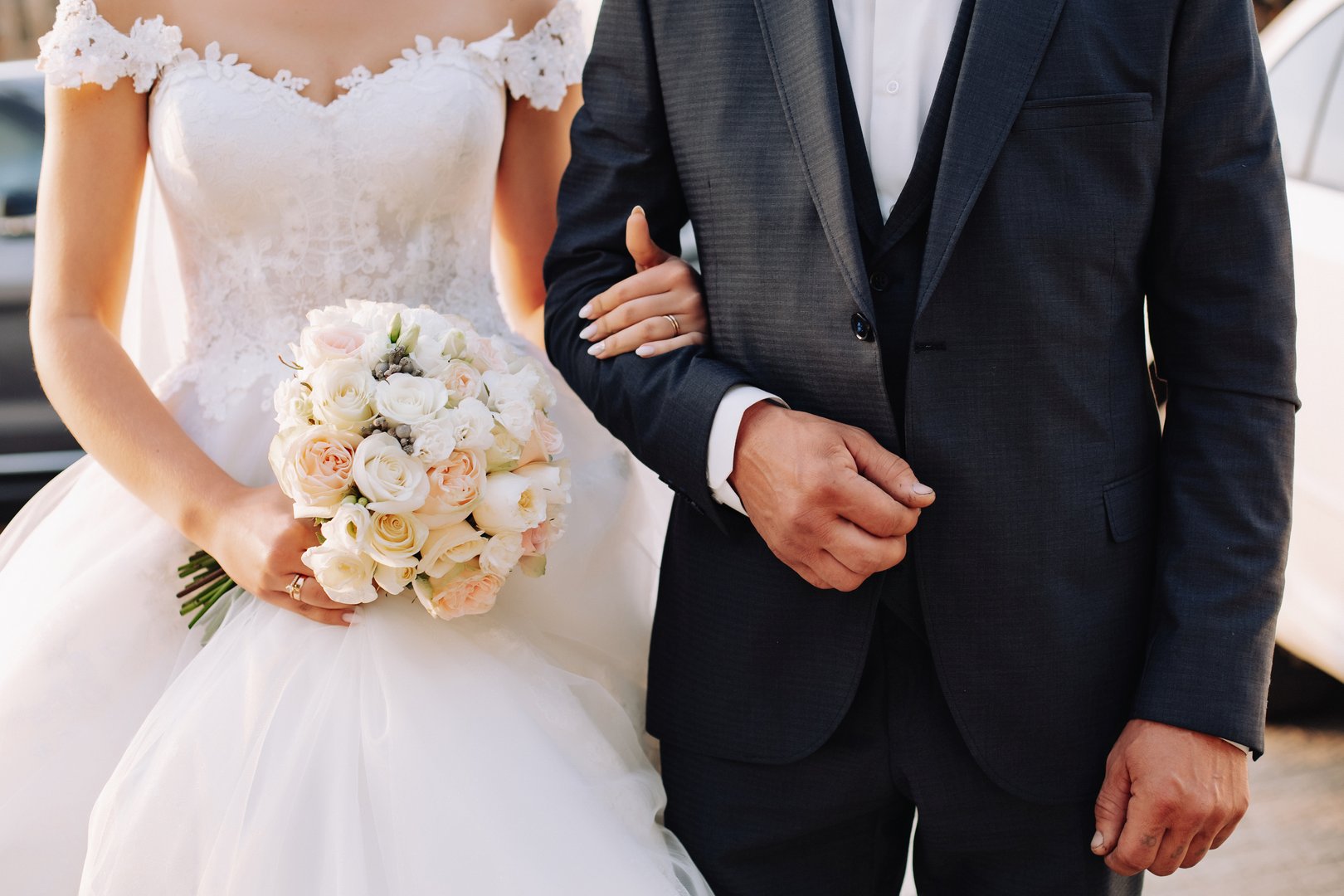 The bride and Father are standing next to each other and a Father holds her Arm. Slim beautiful young bride holding her father's hand before her wedding. Bride and Father Arm in Arm.