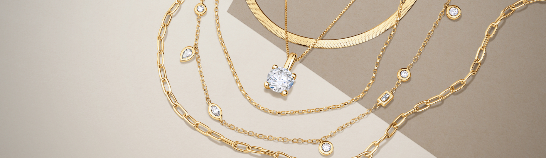 Collection of gold necklaces with various chain styles and diamond accents displayed on a neutral background.