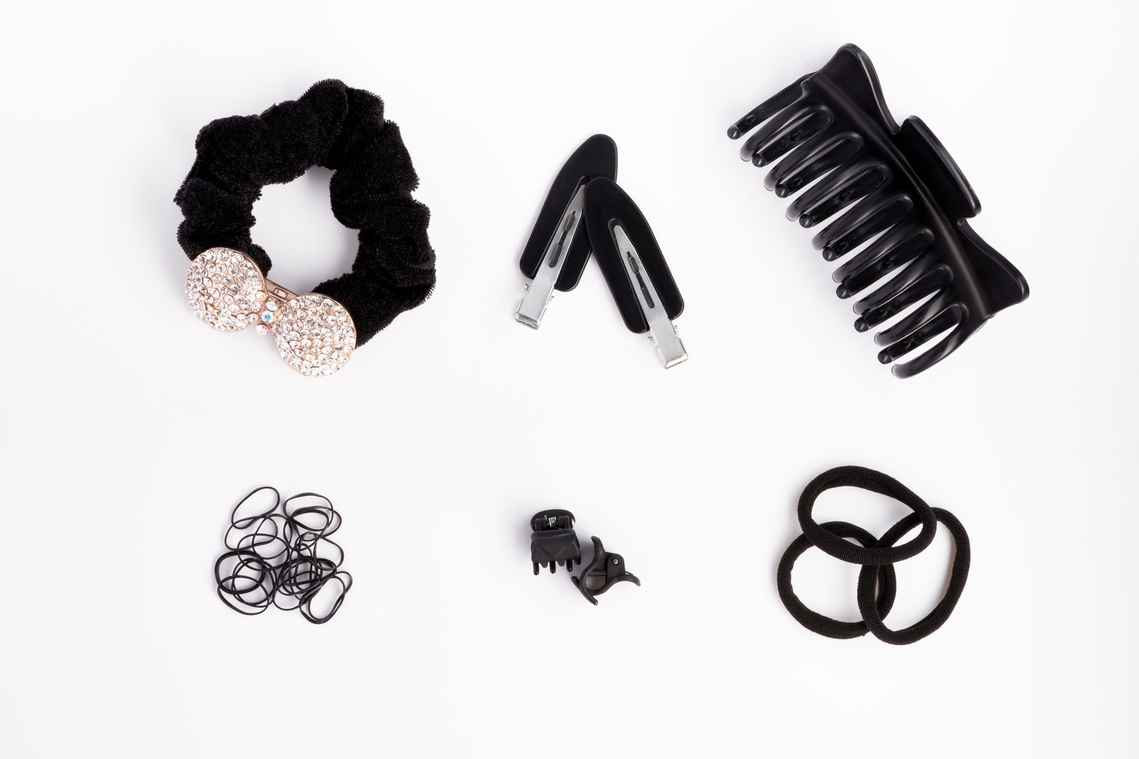 Hair tools and accesories- black hair bands, pins, rubber bands on a white background