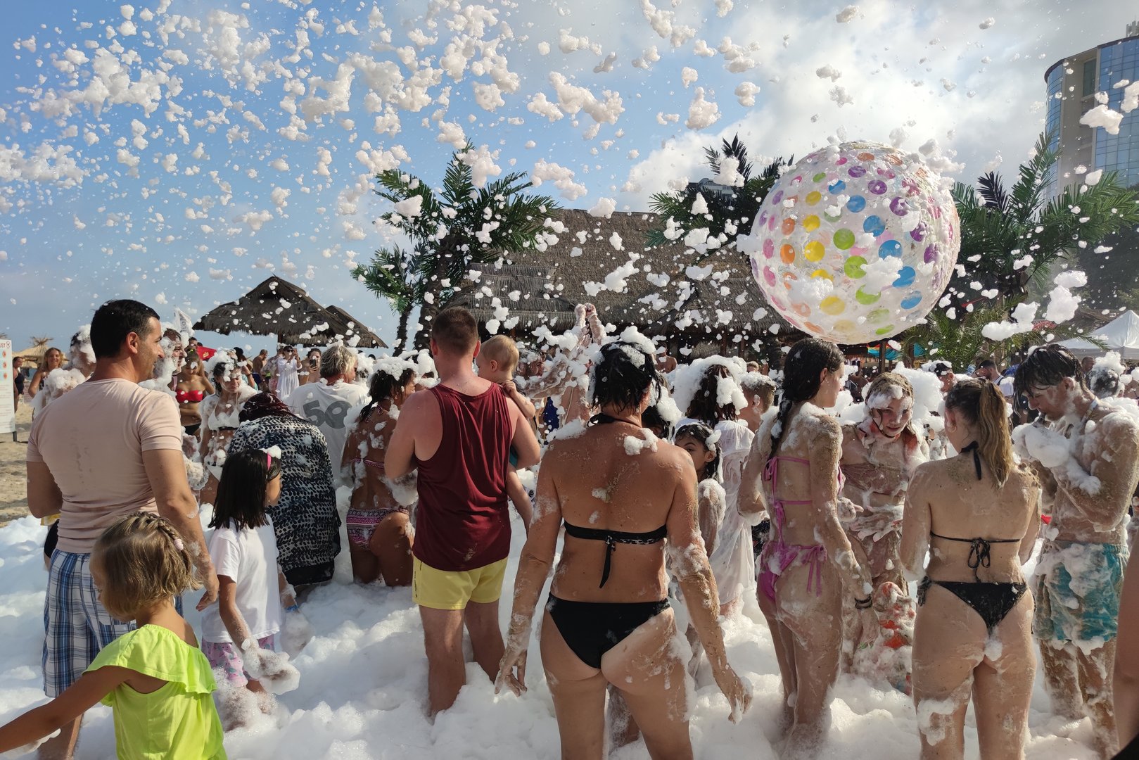 Golden Sands, Bulgaria - July 30, 2022: foam party on the beach, people throw up a big balloon