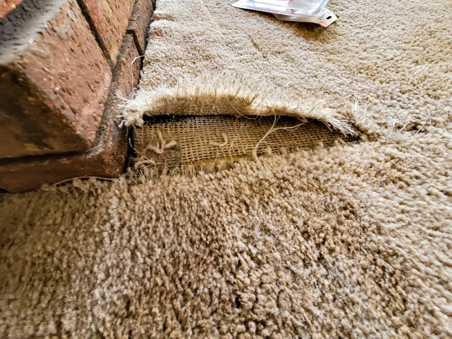Damaged carpet seam before repair