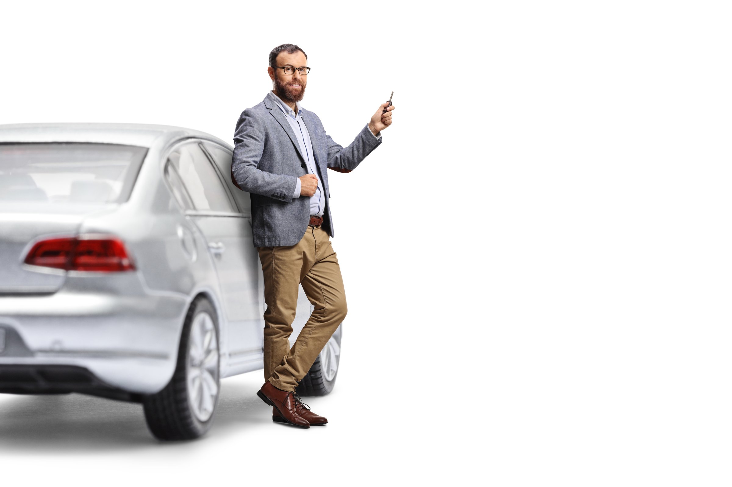 Driver leaning on a car and holding a key isolated on white background